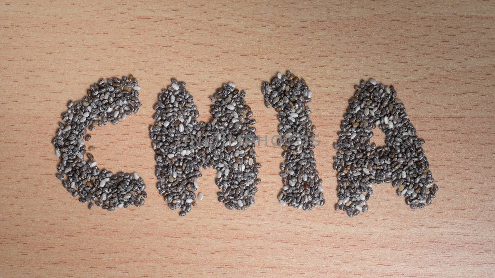chia word made from chia seeds on wooden plate by zneb076