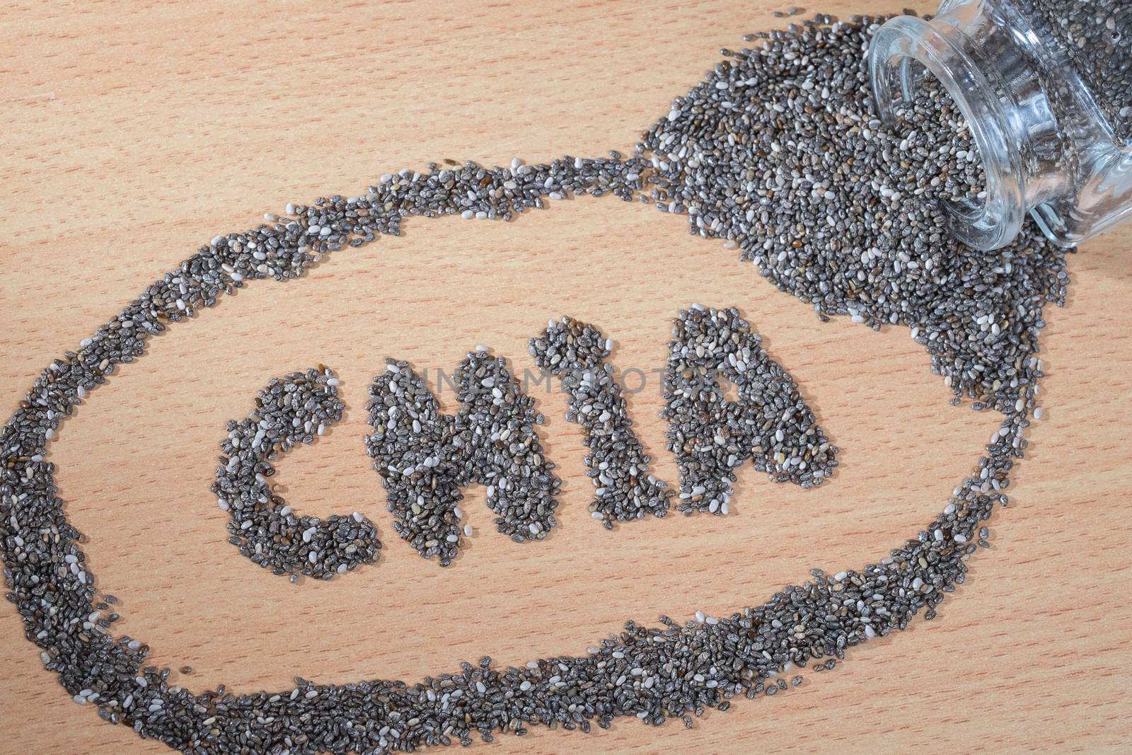 chia word made from pouring chia seeds on wooden plate by zneb076