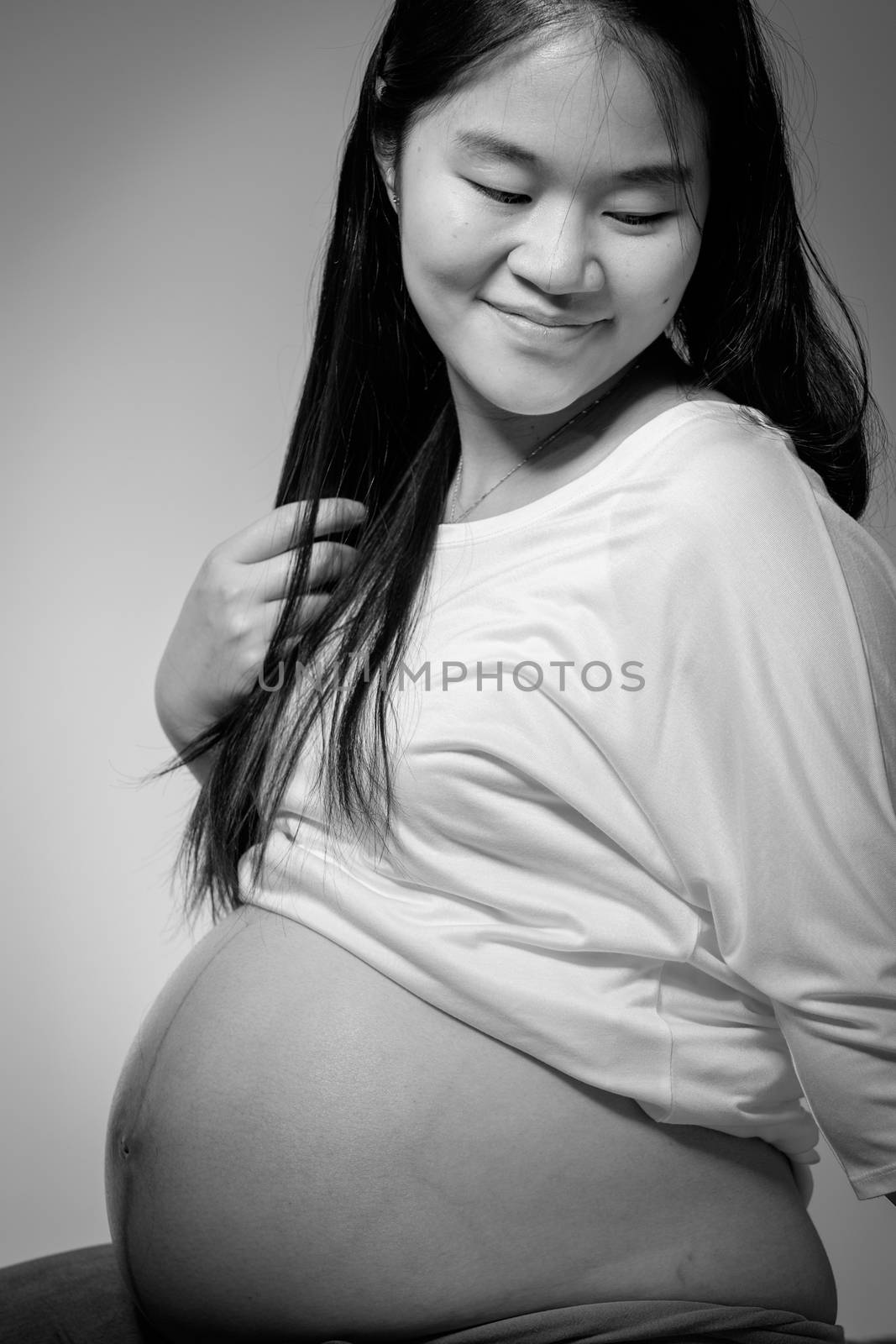 Asian pregnant woman in studio on white background