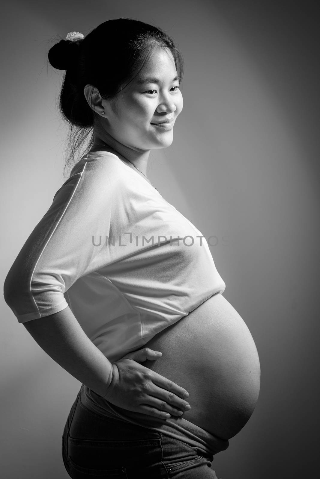 Asian pregnant woman in studio on white background