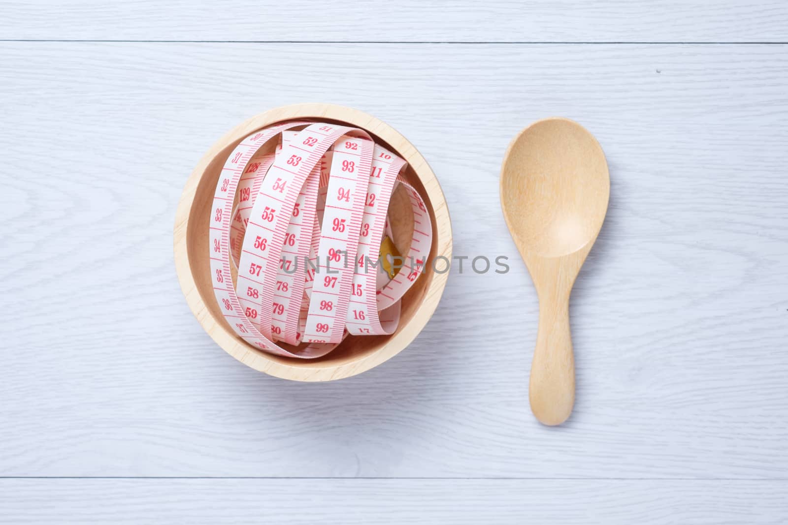 Tape Measure in wooden bowl on the white wooden floor. for someone who want to diet , weight loss
