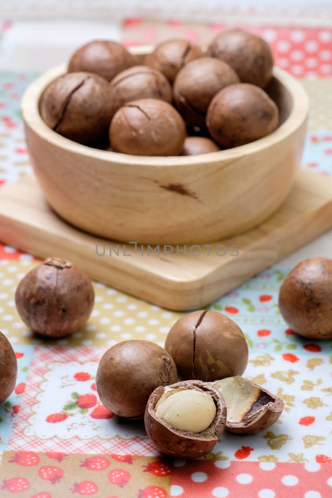 Macadamia on napery and wooden bowl by zneb076