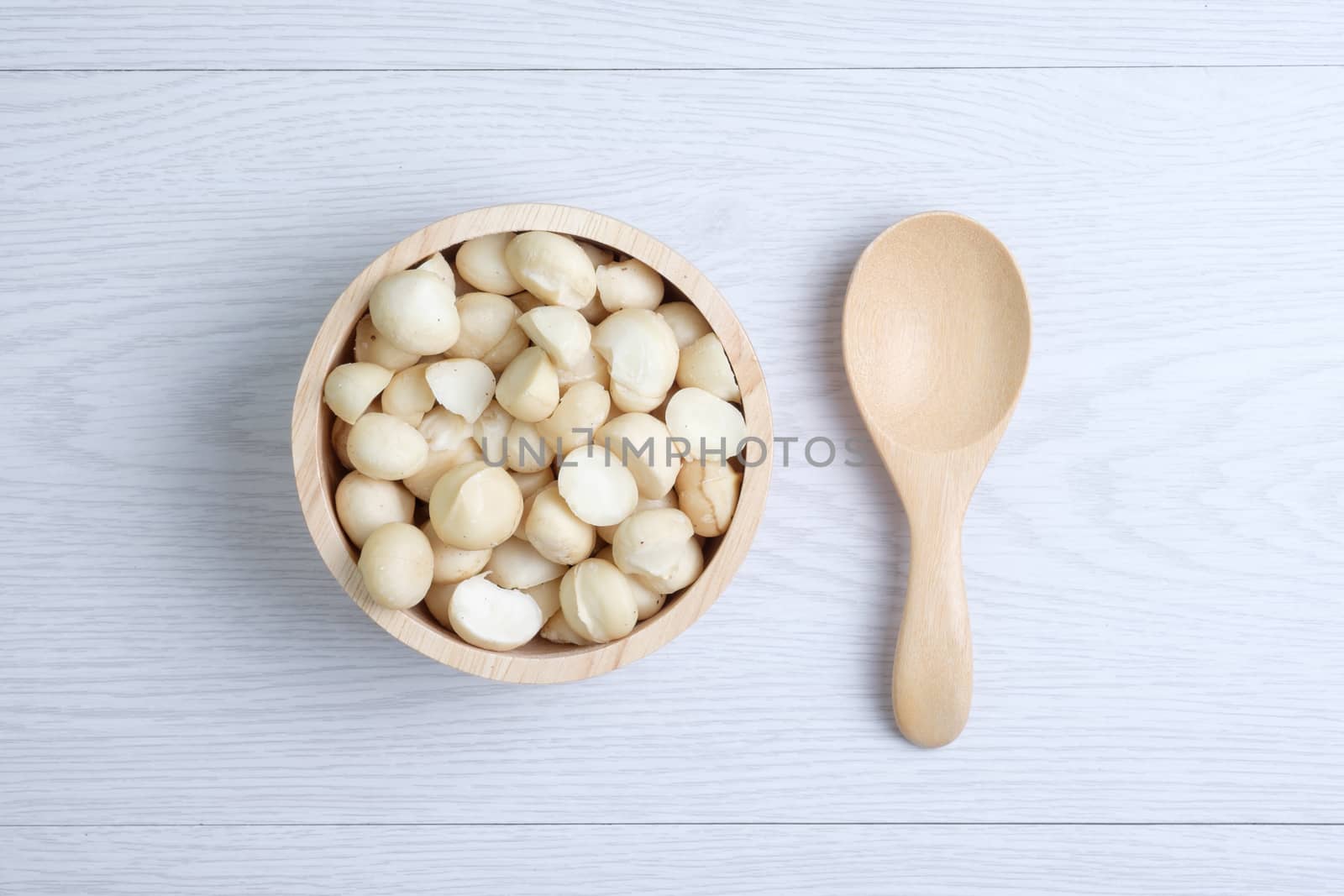 Top view macadamia nuts and shell in wooden bowl by zneb076