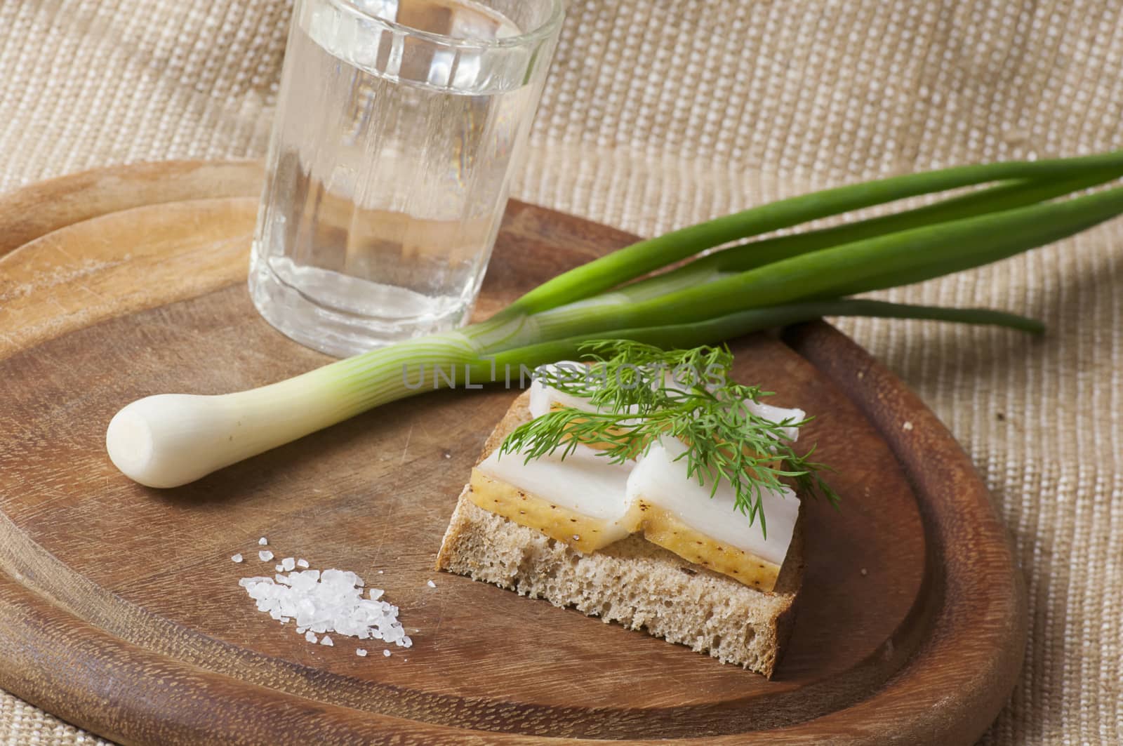 Sandwich with salted lard on rye bread served with vodka, green onion