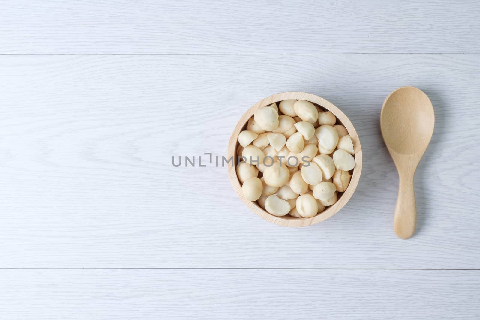 Top view macadamia nuts and shell in wooden bowl by zneb076