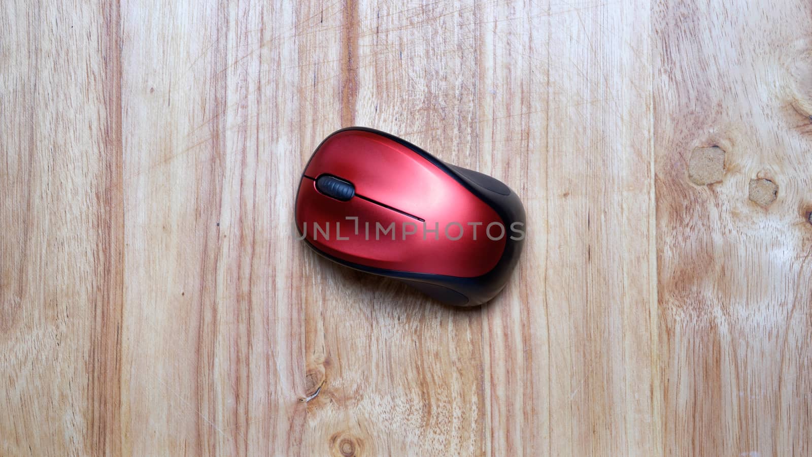 black red wireless mouse on wooden table.