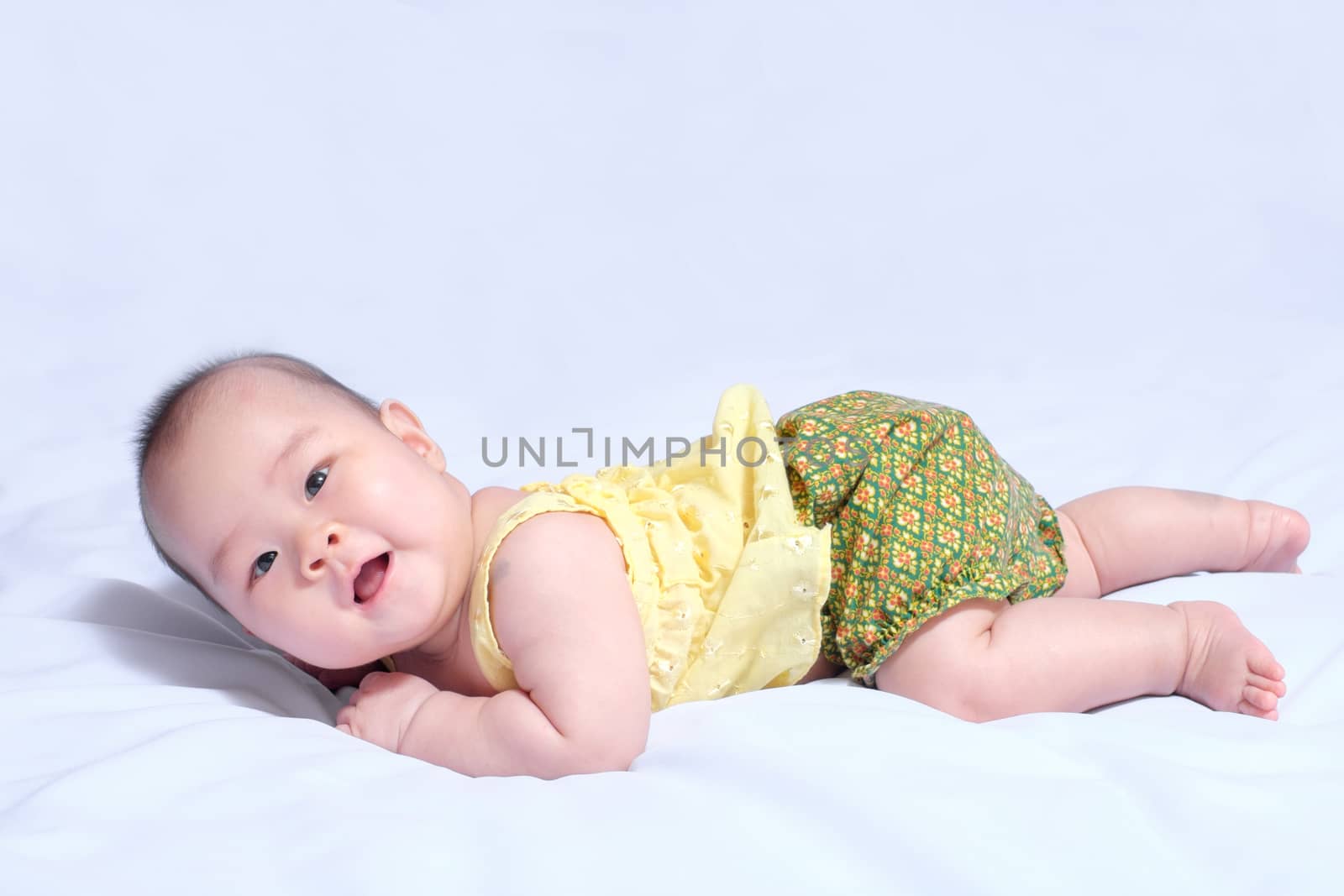 asian baby girl in traditional thai dress, she lie prone, smile , and looking at camera