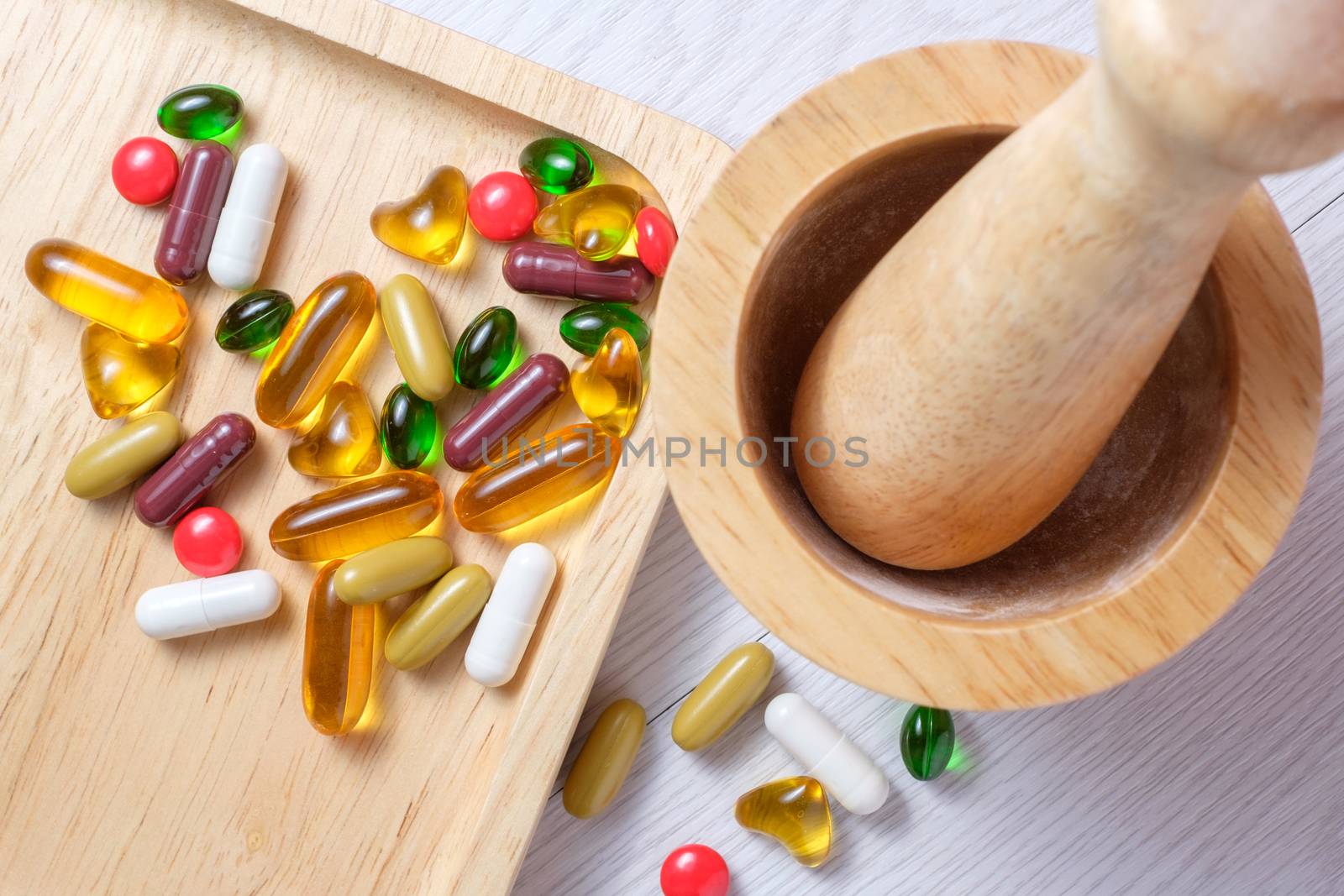 top view of medicine and vitamin on wooden plate near mortar