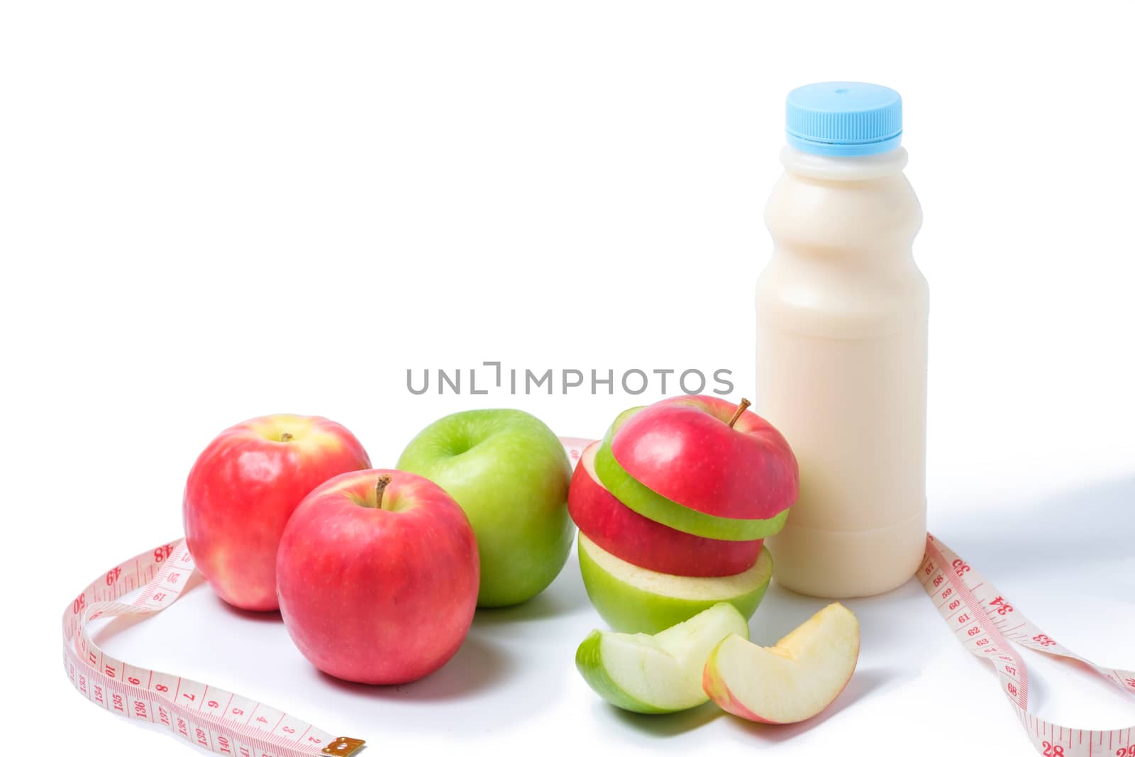 slice red , green apple with waist measure and milk on white background. space for adding your text.
