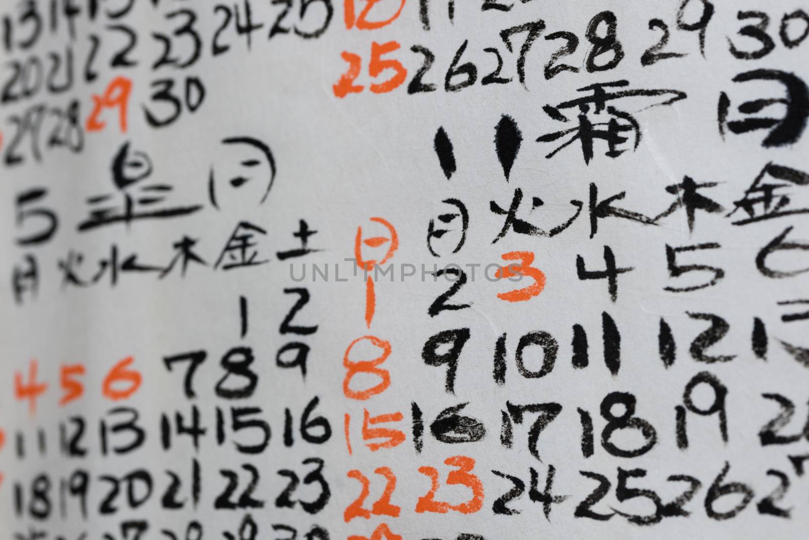 Some hand written numbers and Kanji on a Japanese Calendar.