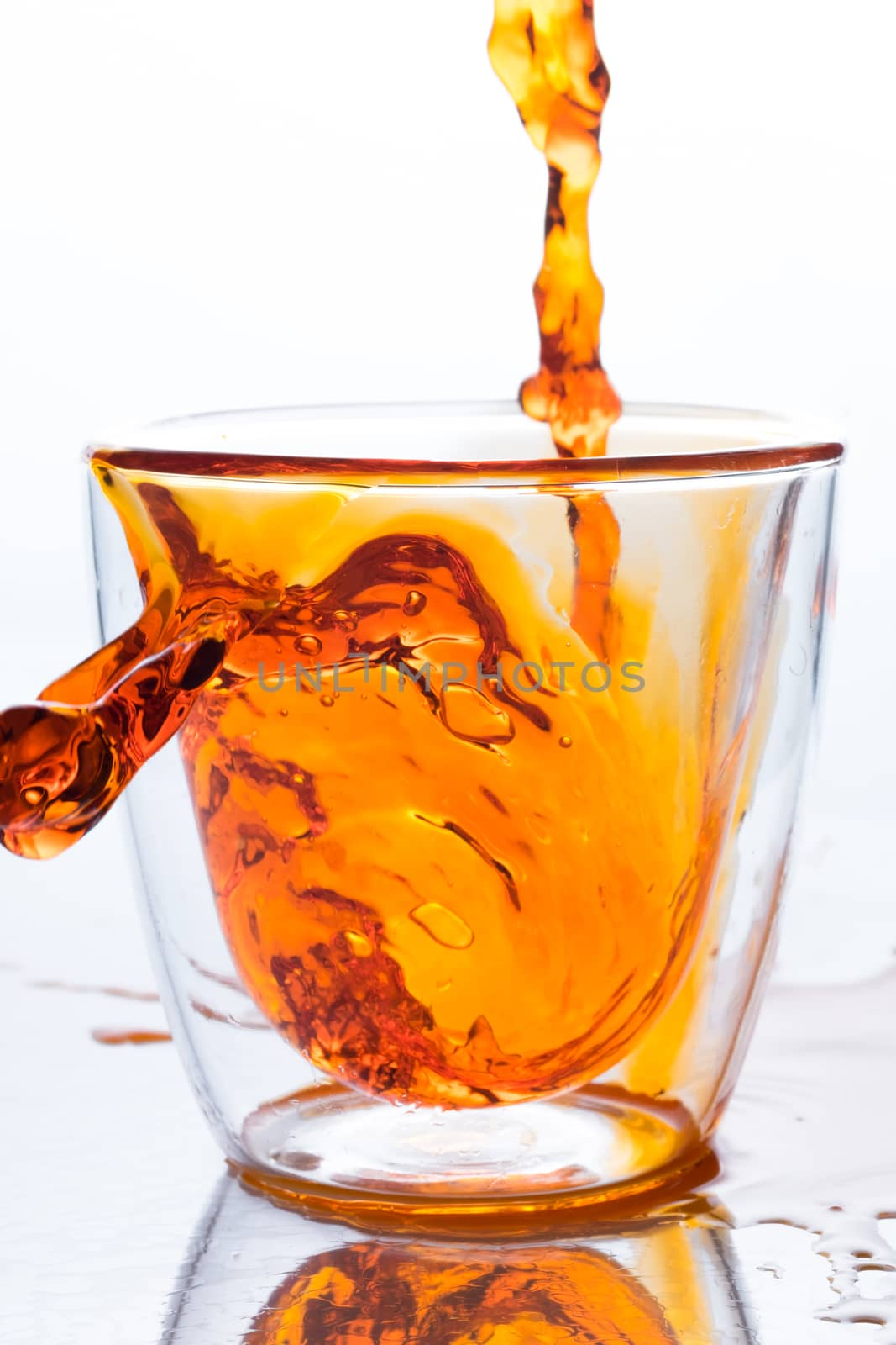 pouring orange water in to clear glass by zneb076