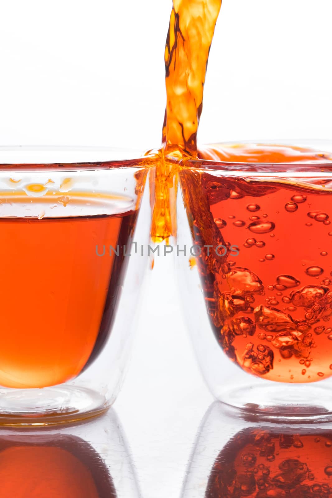 pouring orange water in to clear glass by zneb076