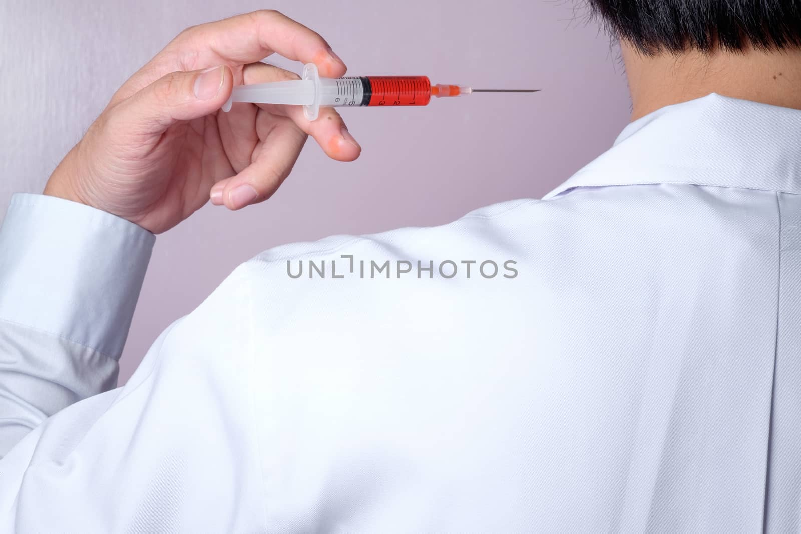 Doctor with syringe, red vaccine syringe, using on himself