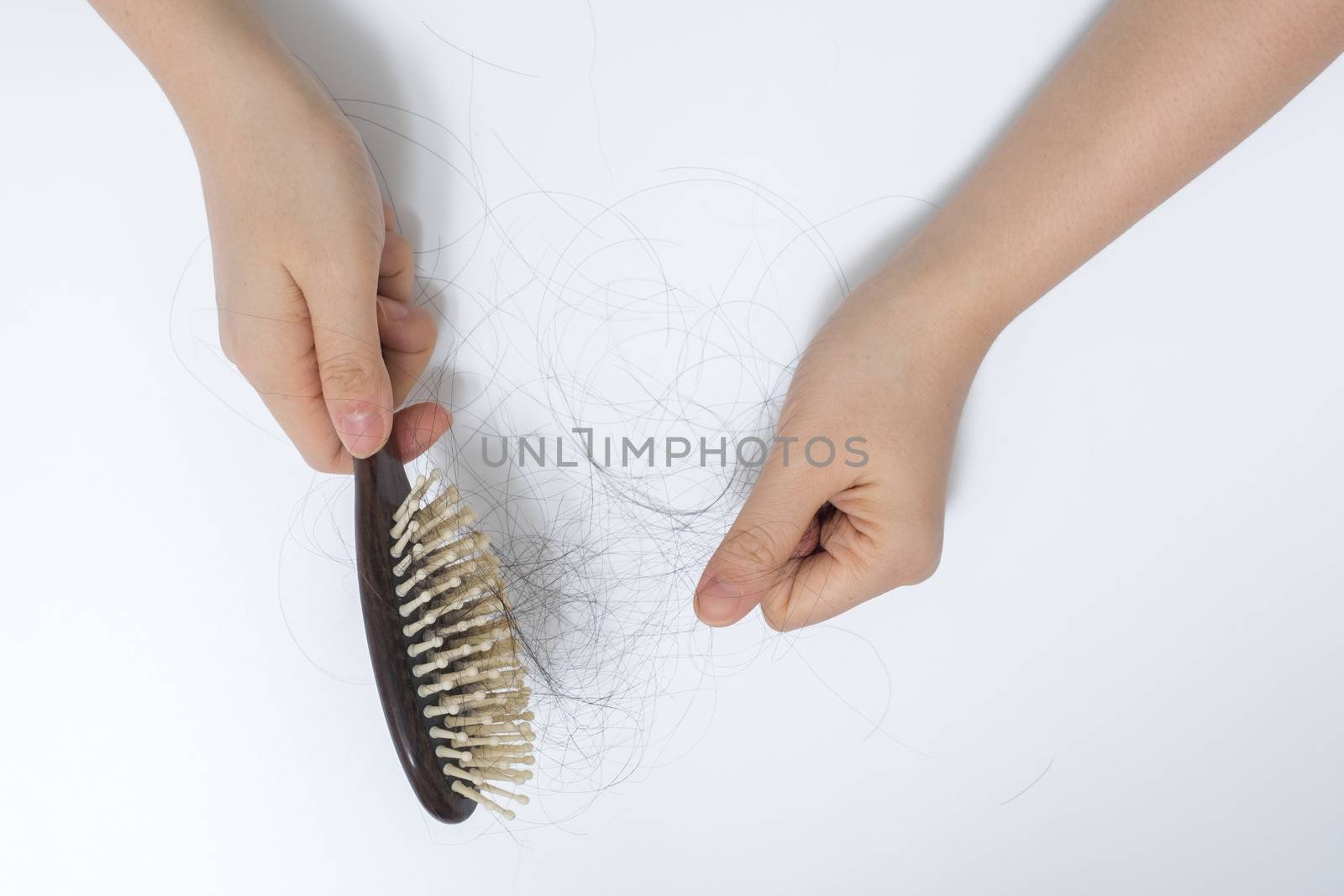Hair loss in woman hands and bruch, on white background, women postpartum defluvium 