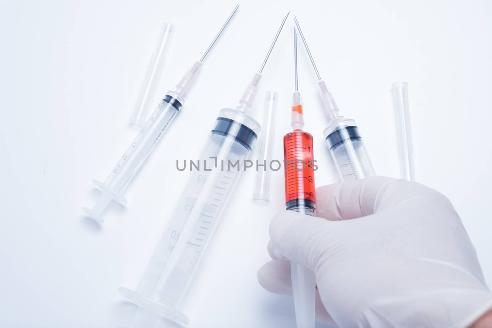 hand holding red vaccine syringe by zneb076