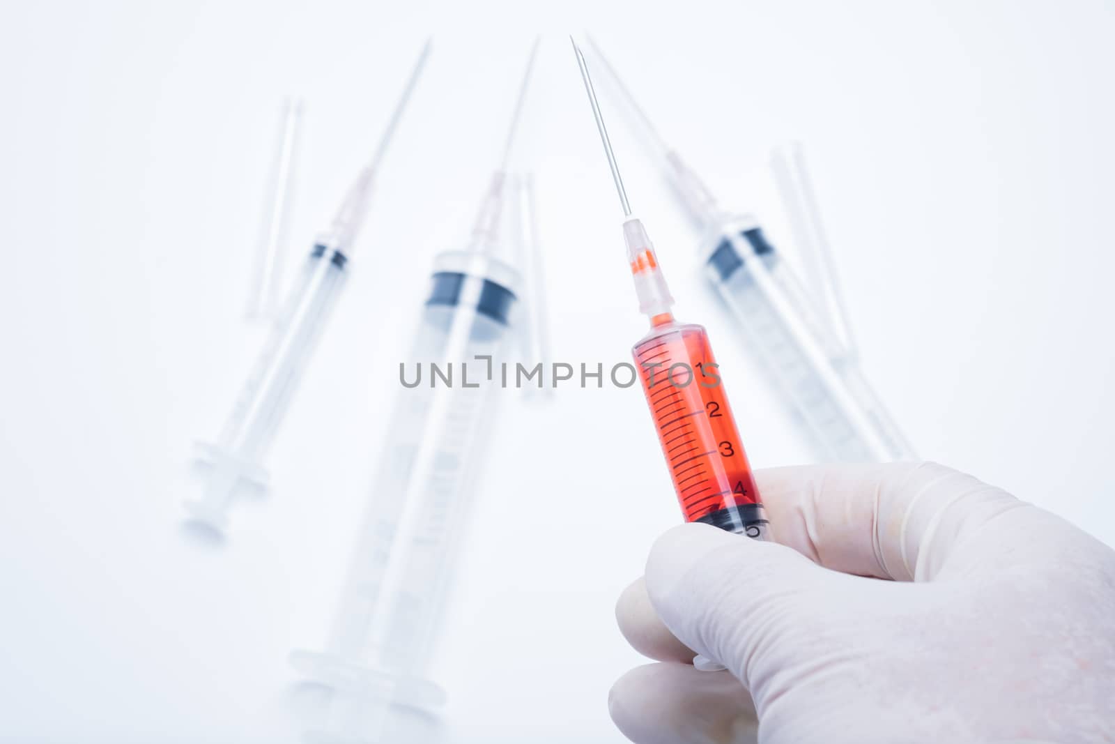 hand holding red vaccine syringe by zneb076