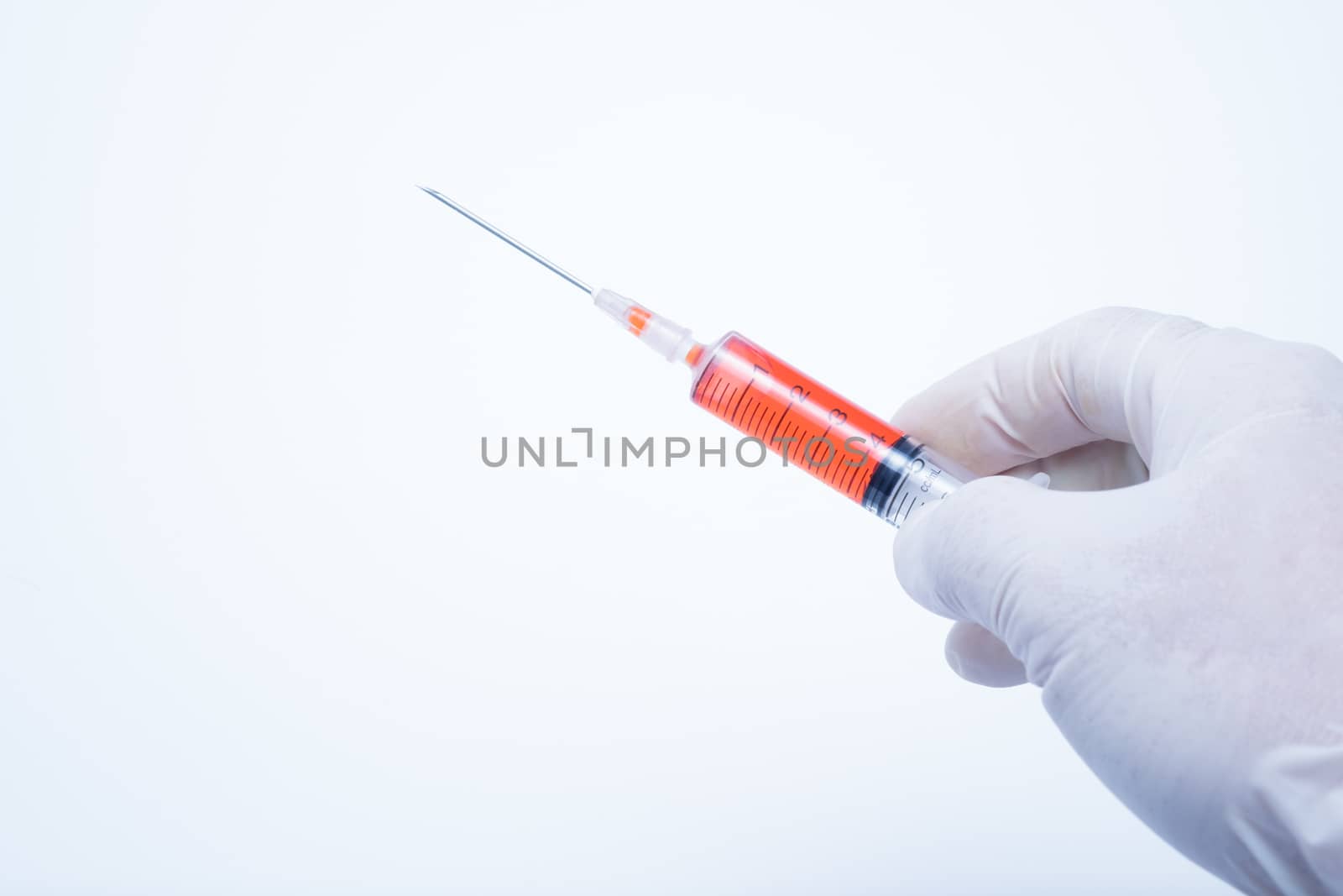 hand holding red vaccine syringe in white background, this photo made to cold mood tone.