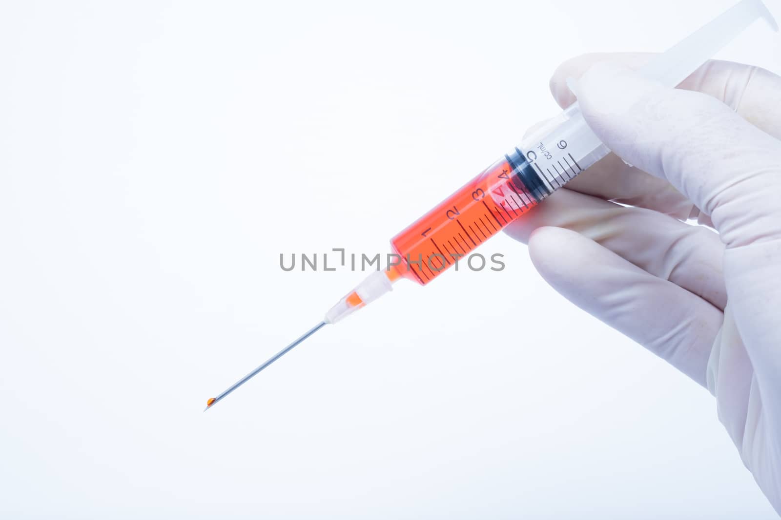 hand holding red vaccine syringe in white background, this photo made to cold mood tone.