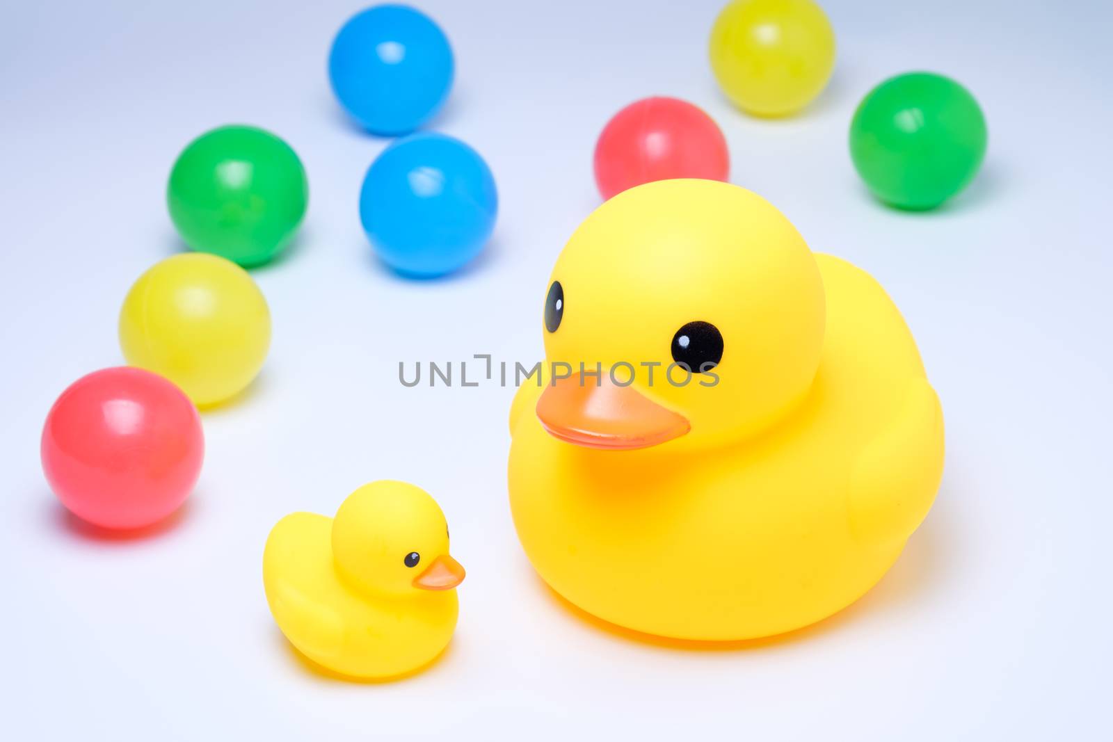 yellow rubber duck with colorful ball in white background
