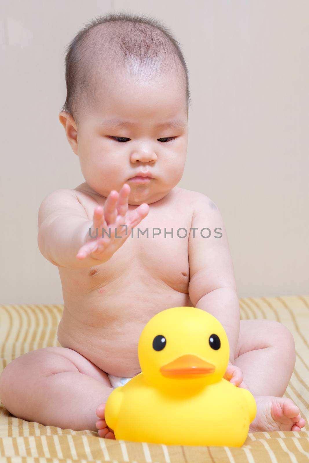 Asian thai baby girl playing with yellow rubber duck