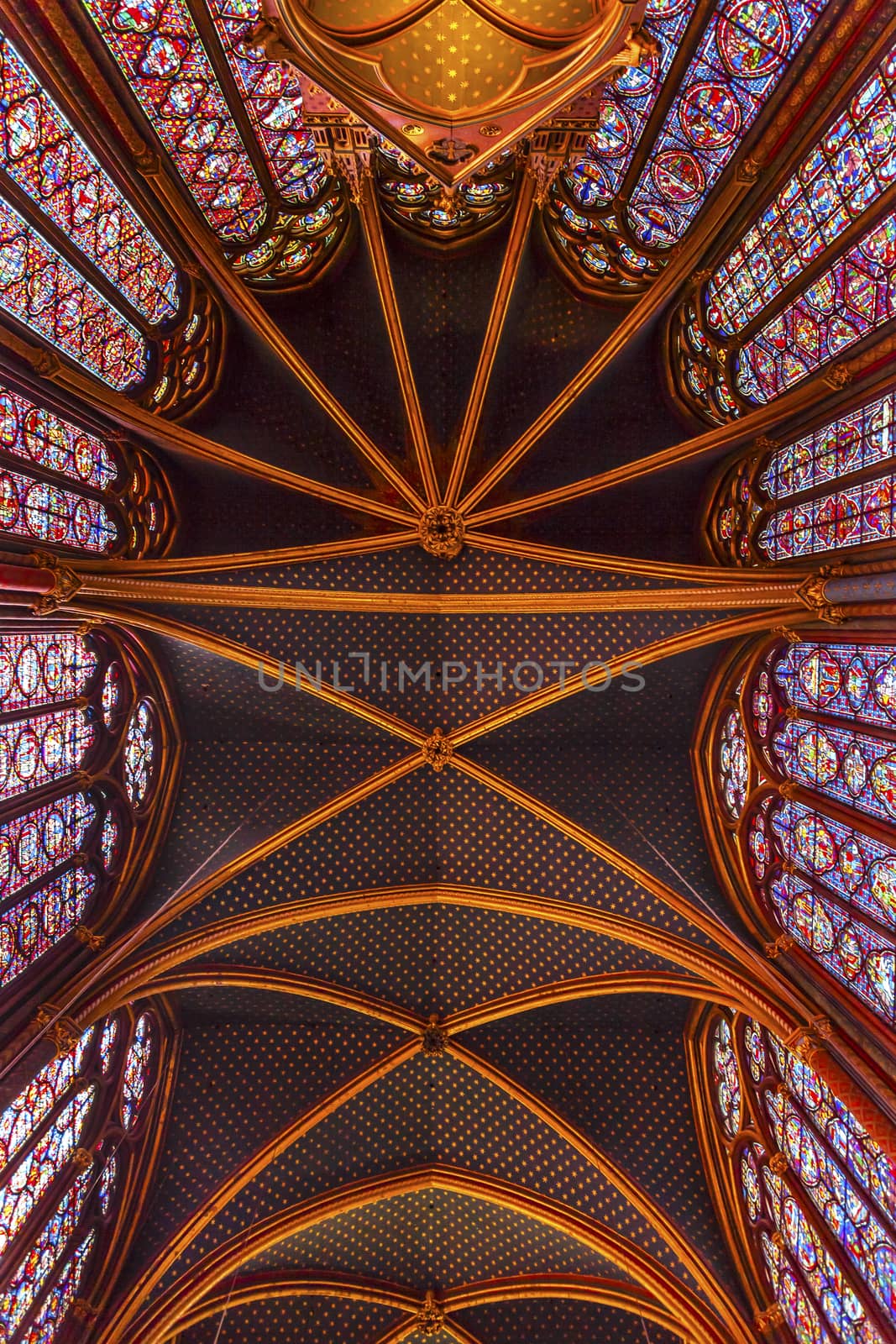 Stained Glass Cathedral Ceiling Saint Chapelle Paris France.  Saint King Louis 9th created Sainte Chappel in 1248 to house Christian relics, including Christ's Crown of Thorns.  Stained Glass created in the 13th Century and shows various biblical stories along wtih stories from 1200s.