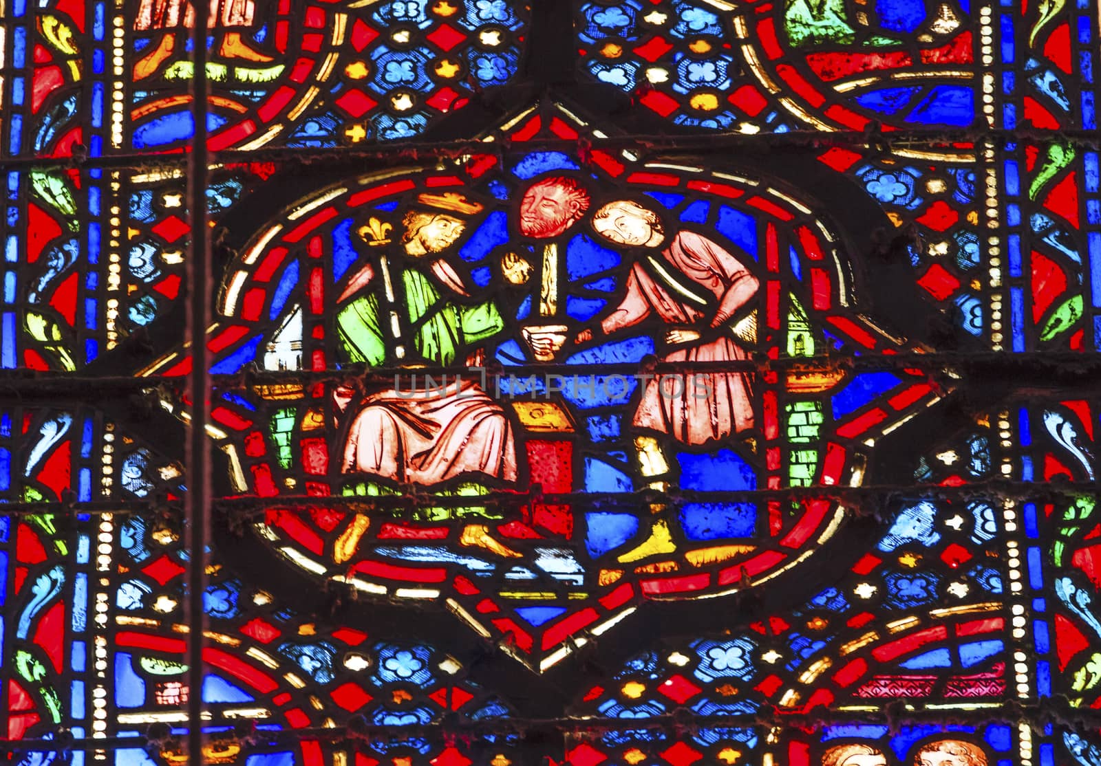Knight Presenting Head of Enemy to KIng Louis 9th Stained Glass Saint Chapelle Paris France.  Saint King Louis 9th created Sainte Chapelle in 1248 to house Christian relics, including Christ's Crown of Thorns.  Stained Glass created in the 13th Century and shows various biblical stories along with stories from 1200s.