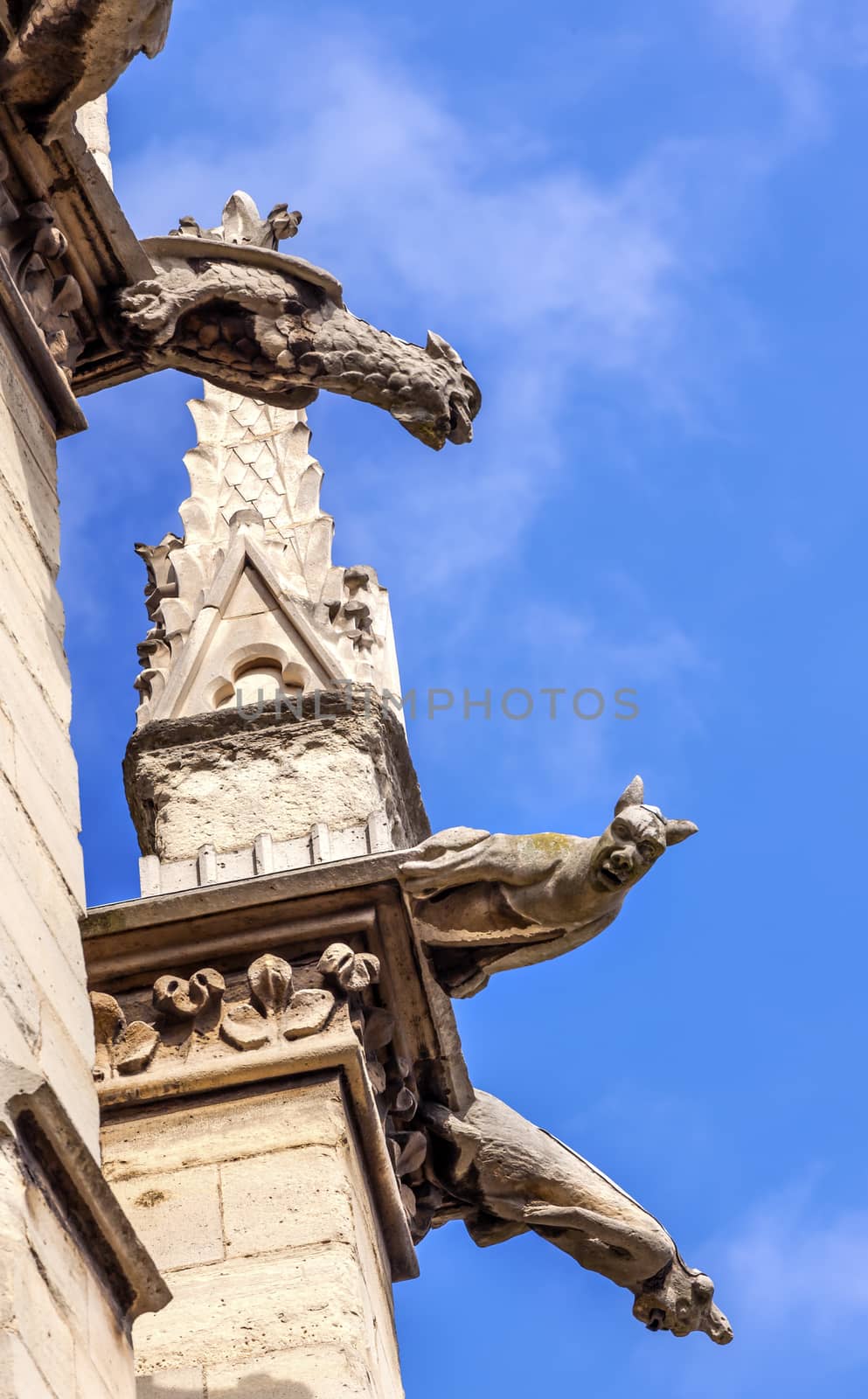 Cathedral Spire Statues Gargoyles Saint Chapelle Paris France.  Saint King Louis 9th created Sainte Chappel in 1248 to house Christian relics, including Christ's Crown of Thorns. 