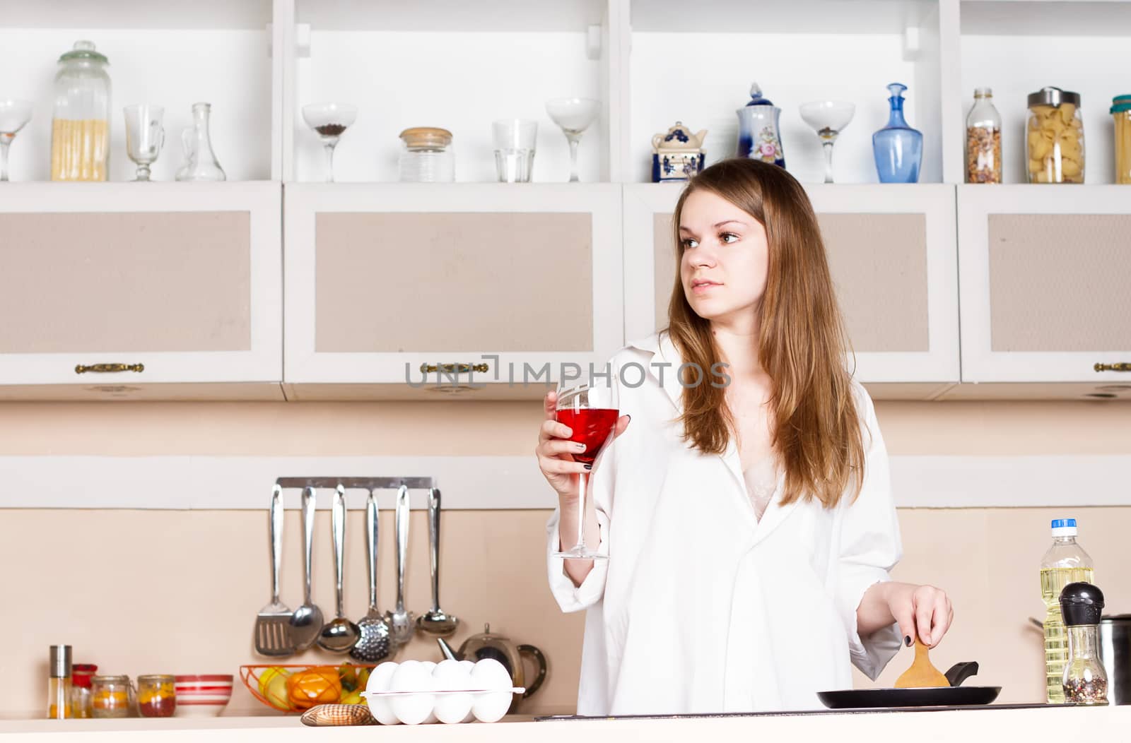 Girl in the kitchen with a glass of red wine by victosha