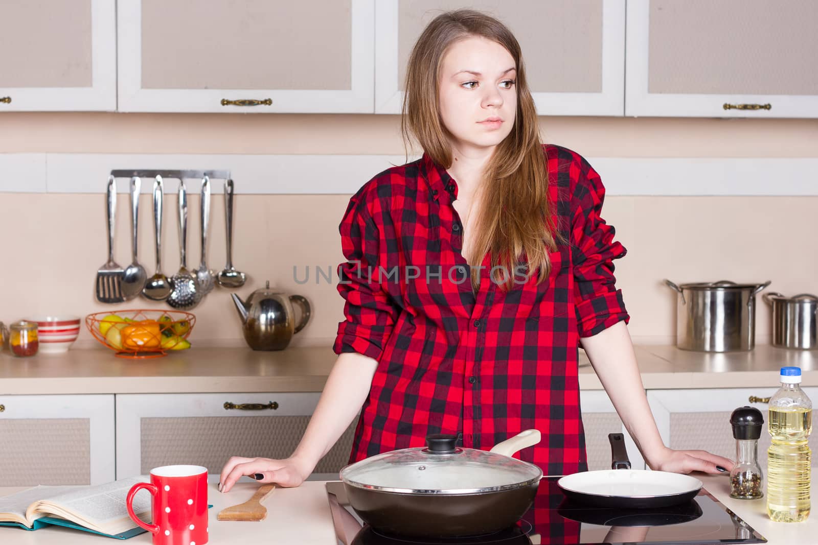 girl is lost in thought over the stove