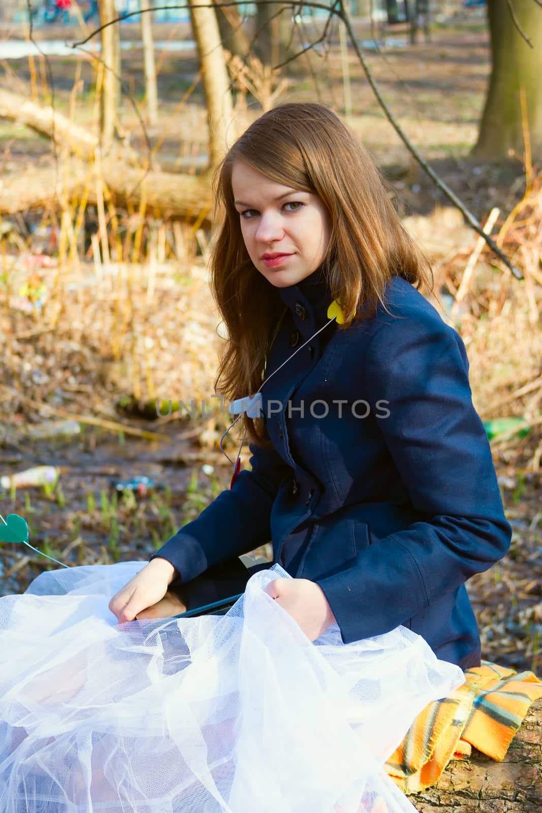 Girl in a blue coat and white tulle skirt in the park