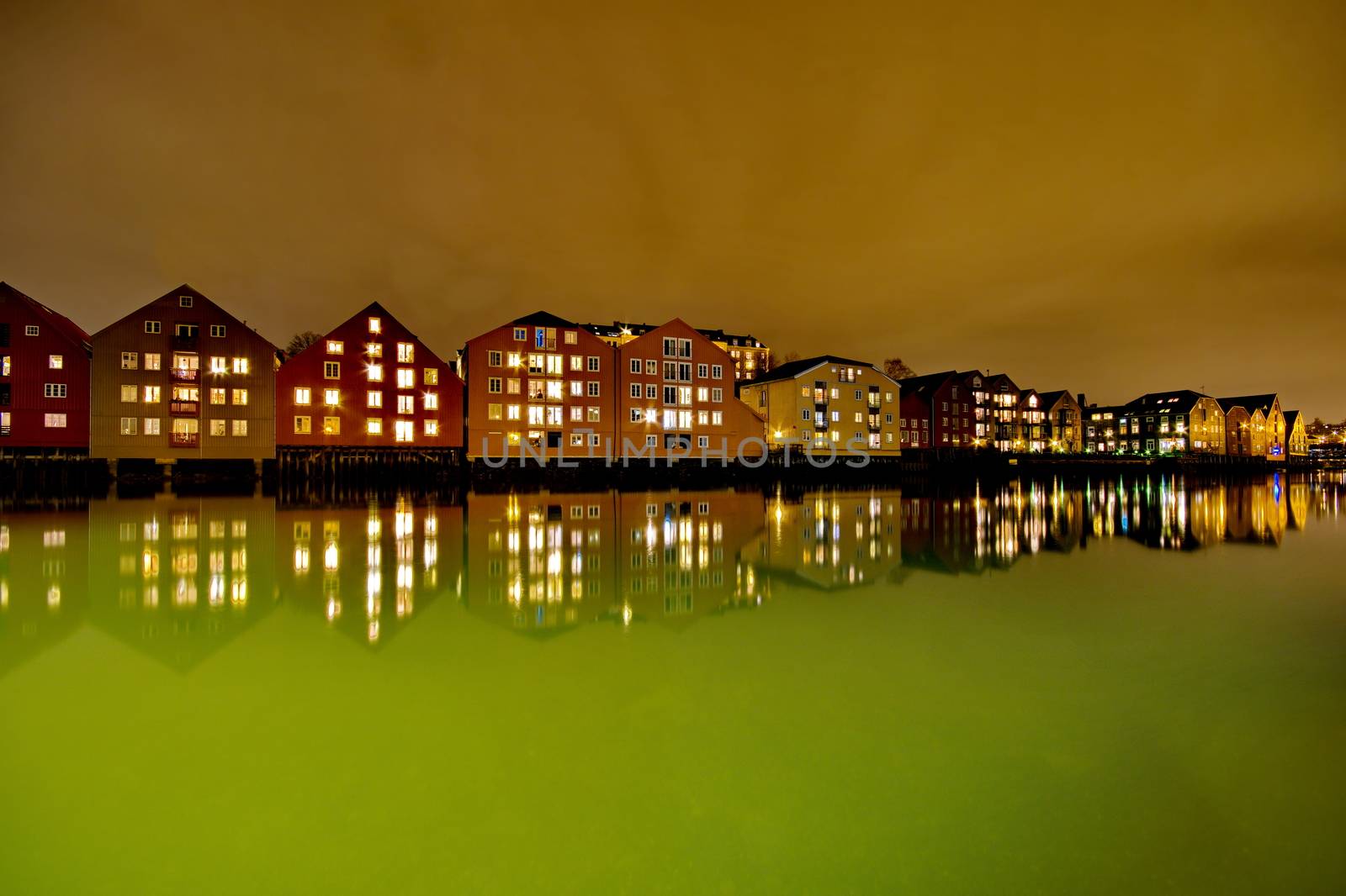 Houses on the water at night in Trondheim, Norway by anderm