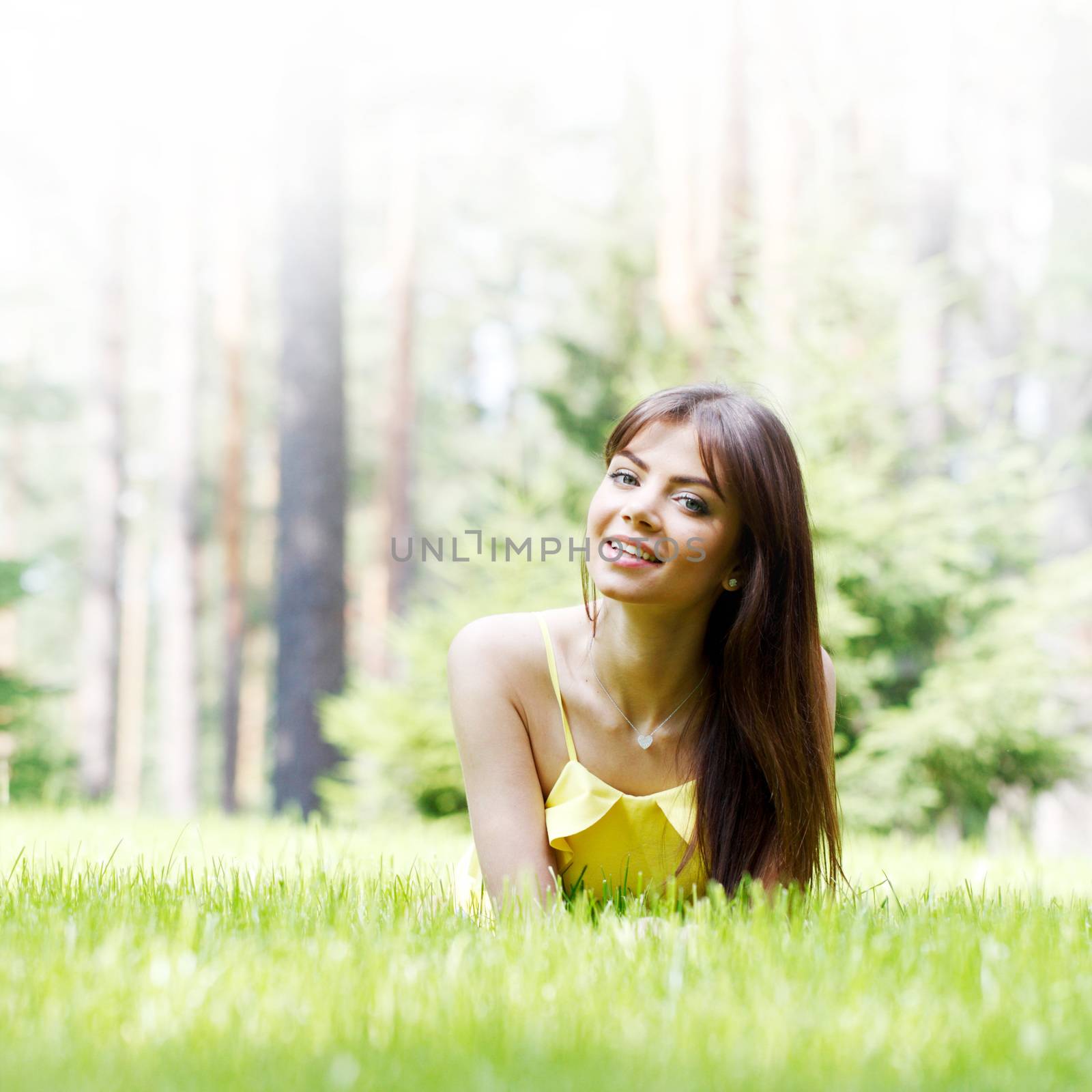 young woman in yellow dress lying on grass by Yellowj