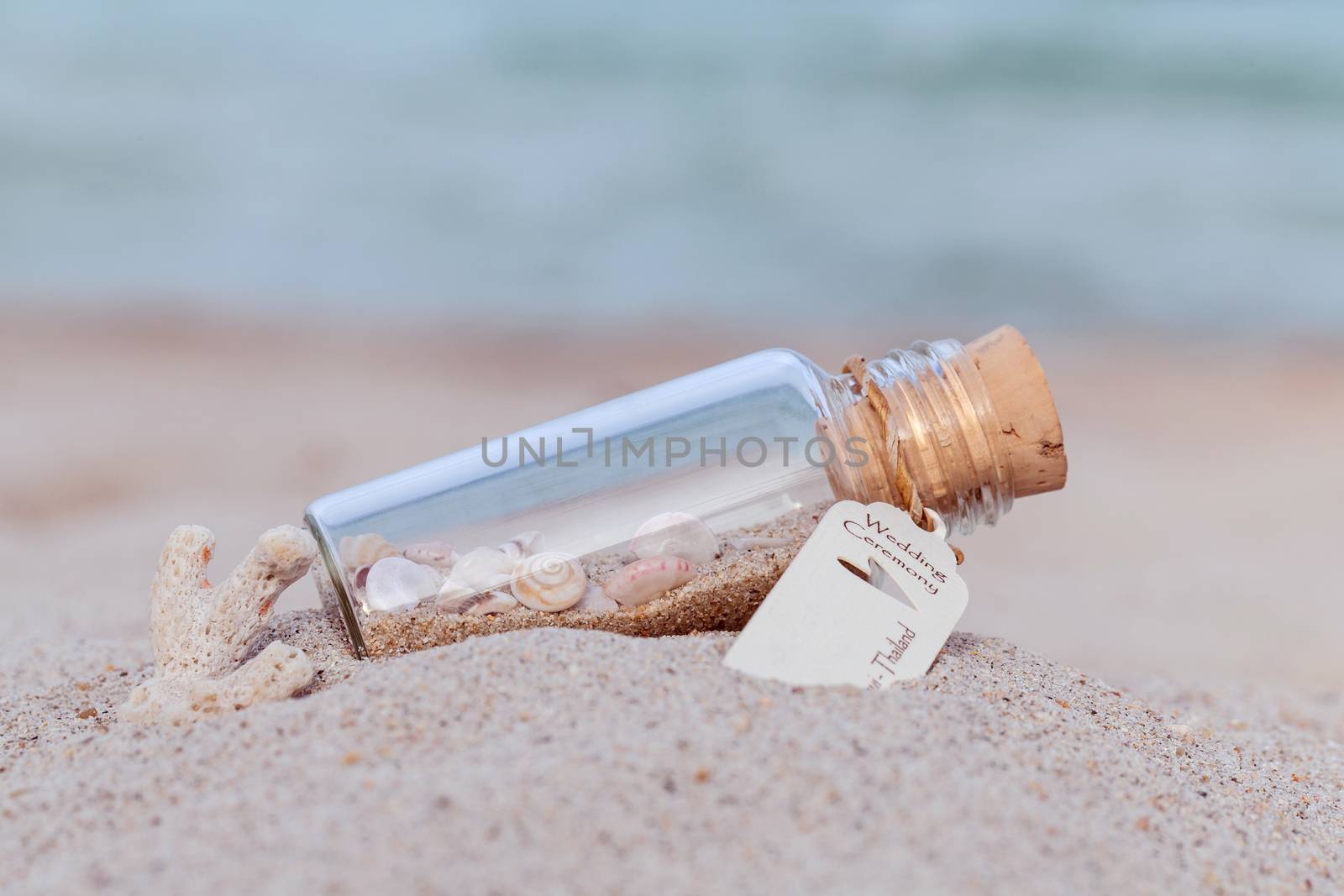 Sand and sea shell in bottle  put on the beach concept for wedding invitation or wedding gift venue on the beach .