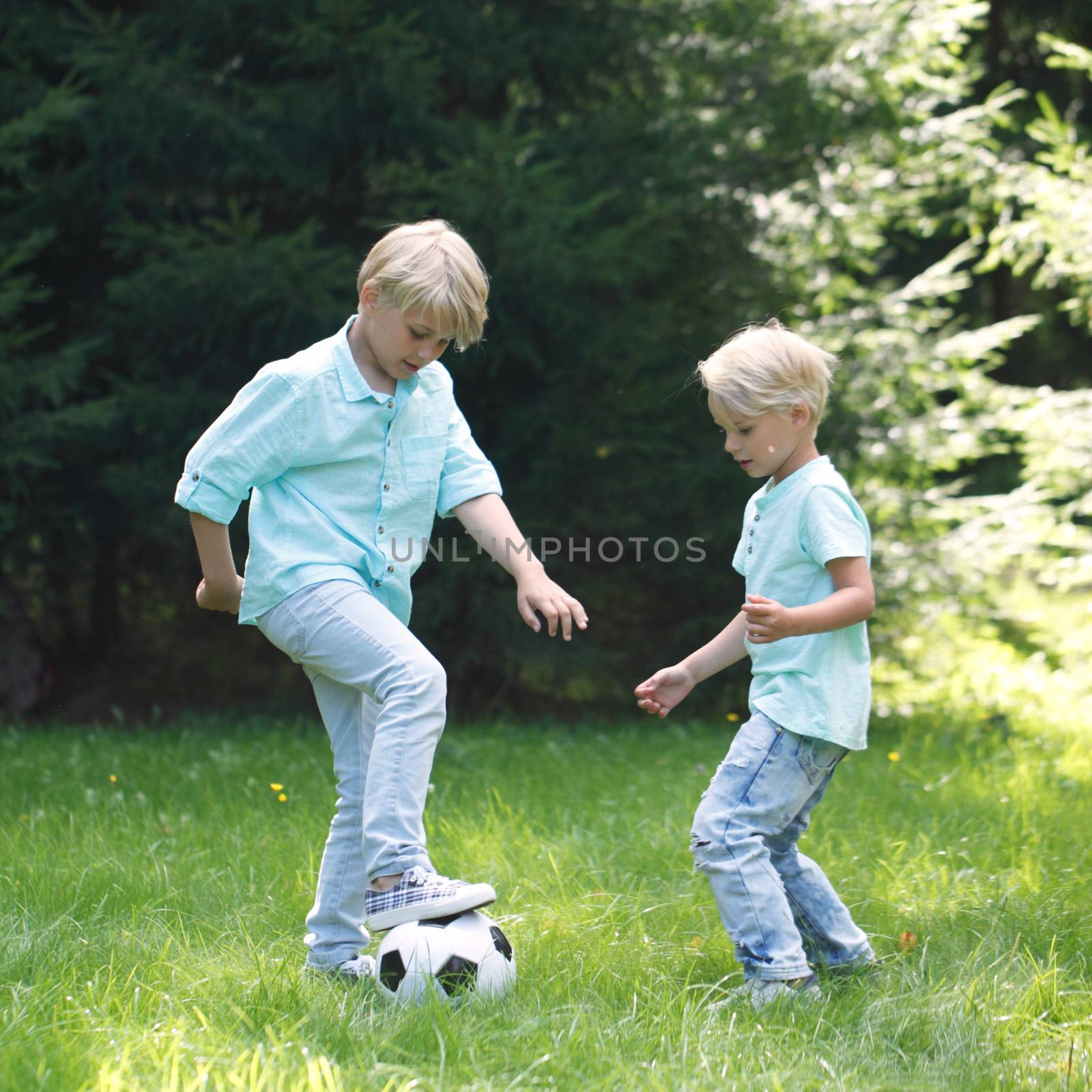 two kids playing football at the park