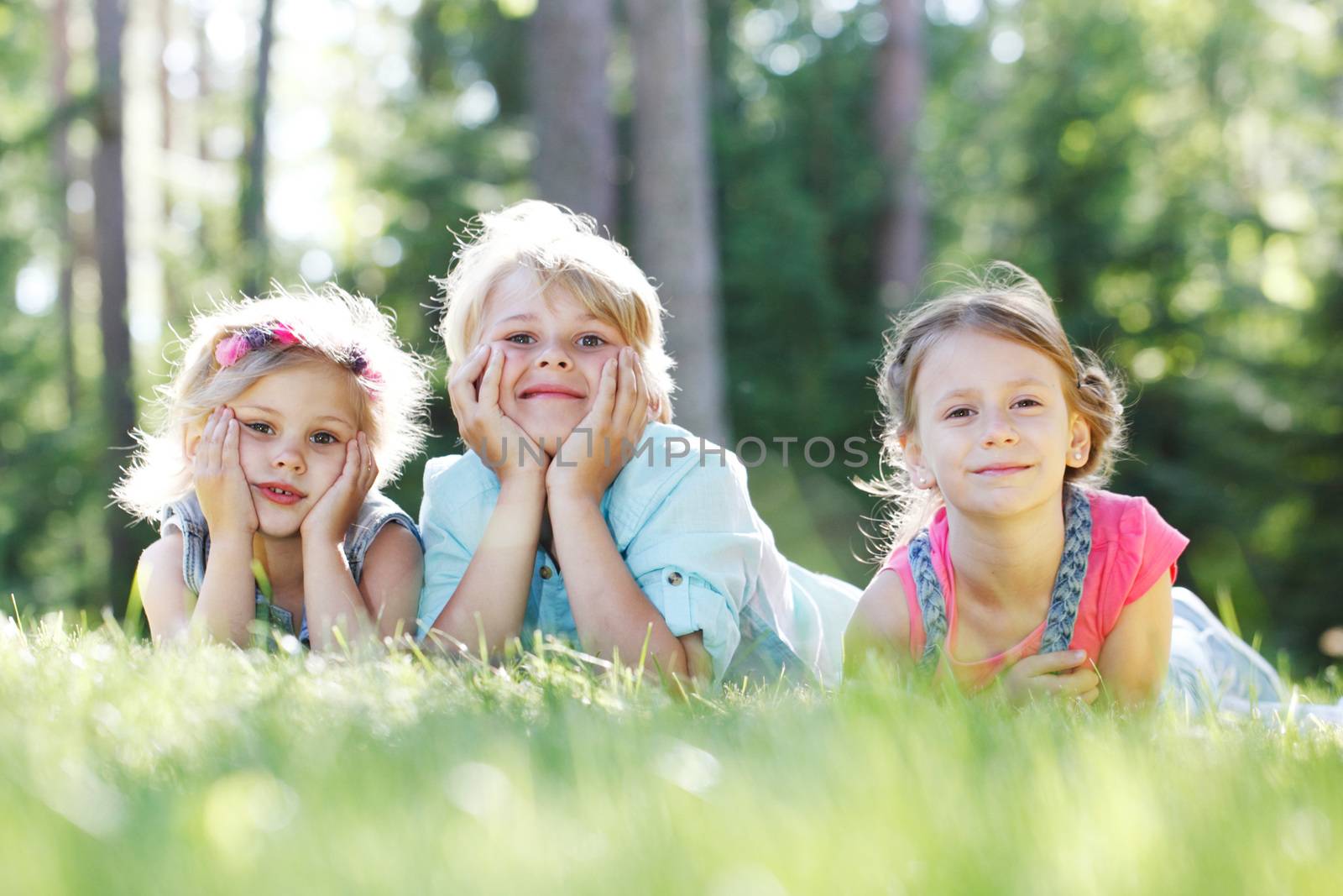 kids lying on grass by ALotOfPeople
