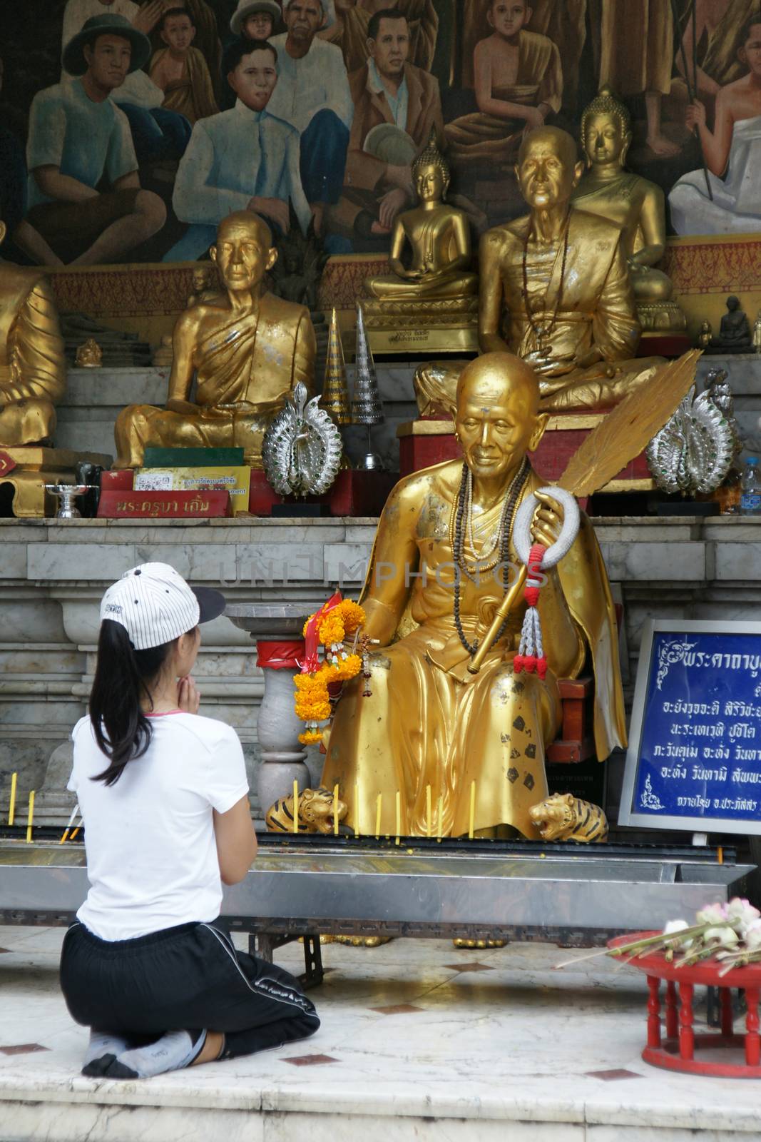 Unidentified female tourism pray to monk sculpture by mranucha