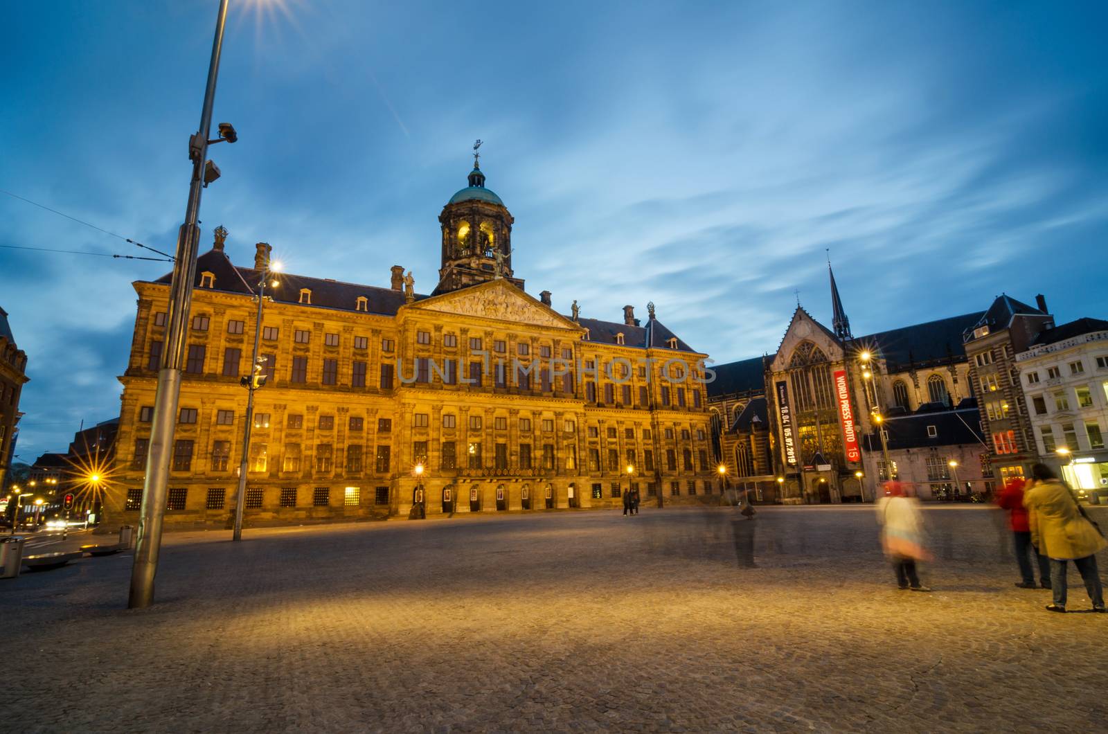 Amsterdam, Netherlands - May 7, 2015: Tourist visit Dam Square with a view of the Royal Palace and the Nieuwe Kerk in Amsterdam, Netherlands. Its notable buildings and frequent events make it one of the most well-known and important locations in the city and the country.