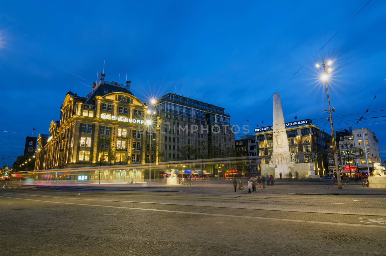 Amsterdam, Netherlands - May 7, 2015: People visit The Dam monument on May 7, 2015. The stone pillar is a National Monument, designed by J.J.P. Oud and erected in 1956 to memorialize the victims of the World War II.