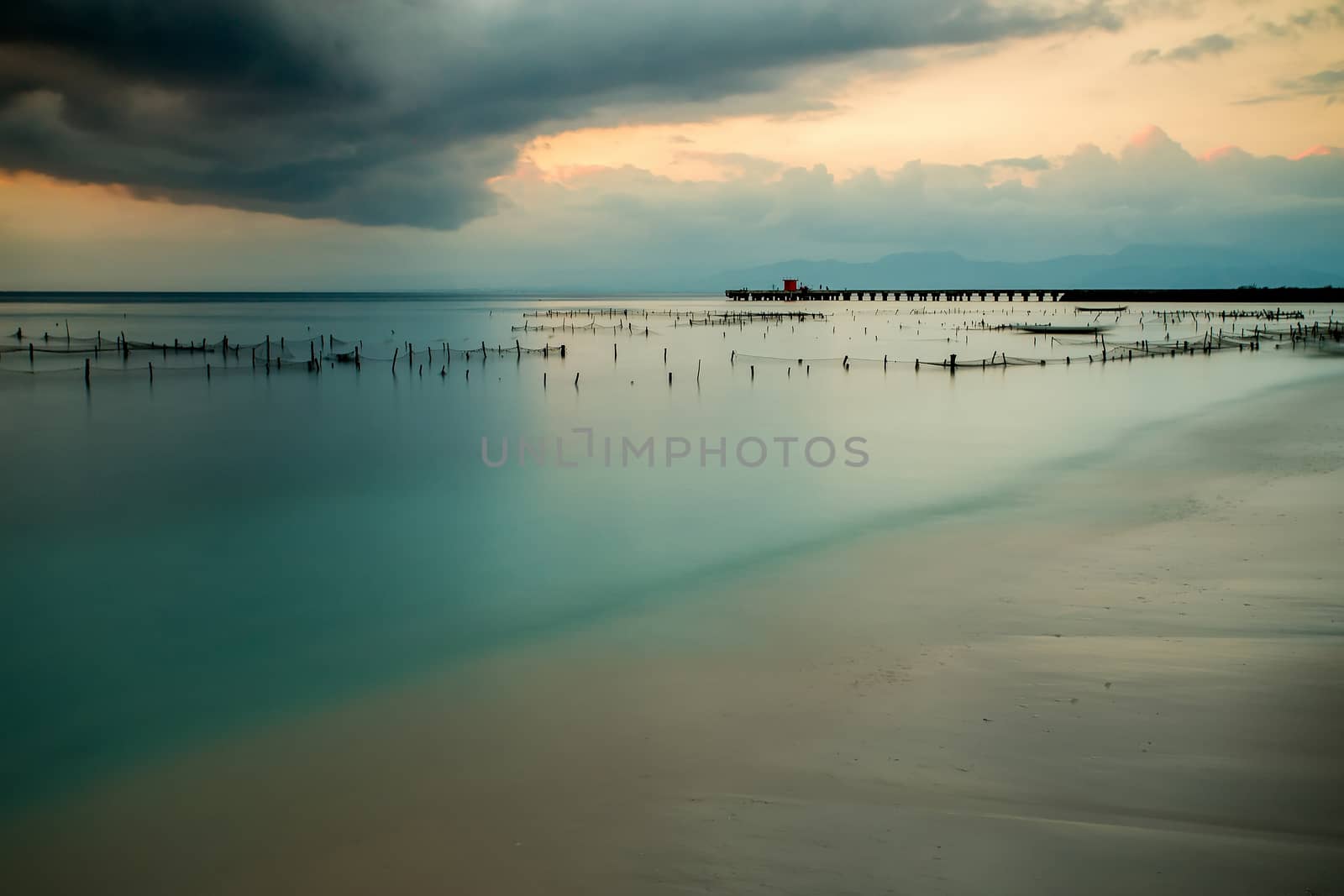 Bali beach, Nusa Penida Island, Toyapakeh, Indonesia - Plantations of seaweed, algae at low tide, long exposure shoot at evening with dramatic sky