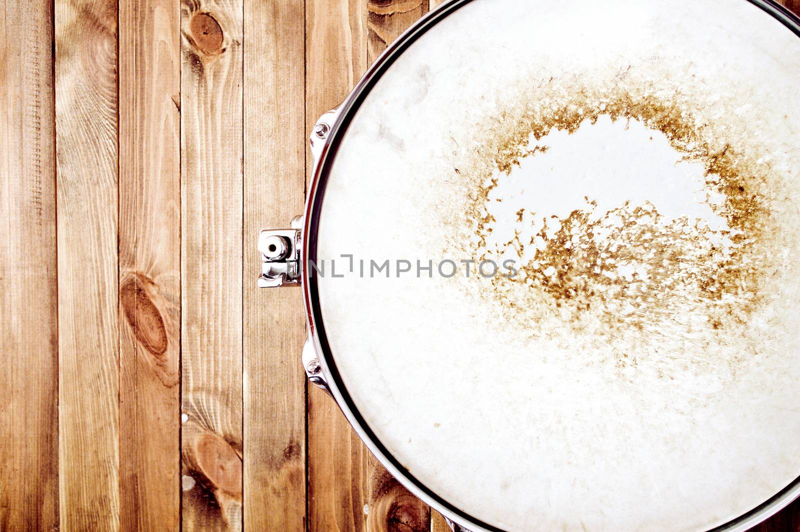 Drums conceptual image. Picture of snare drum lying on wooden background. Retro vintage instagram picture.