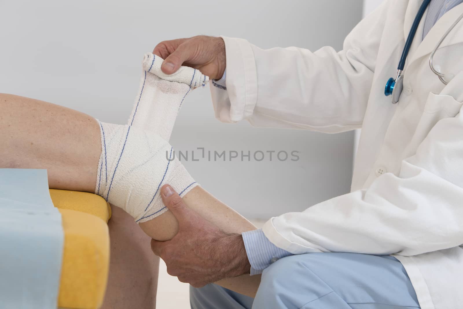 Closed view of a doctor bandaging female patient knee