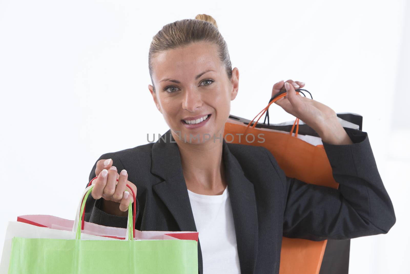 Young beautiful shopping woman during sale holding many colorful by JPC-PROD