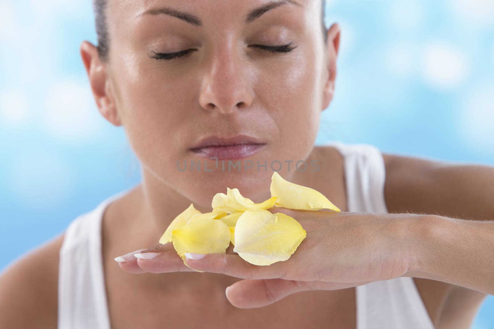lovely woman smelling yellow rose petals