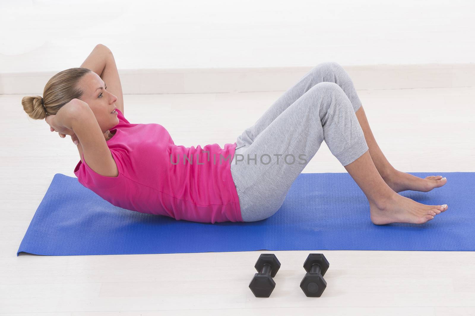 young woman adoing abs in gym