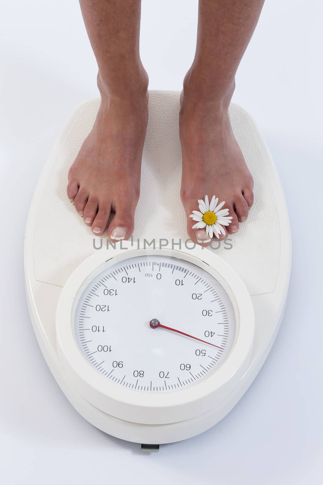 Woman stands on weighing scales isolated on white