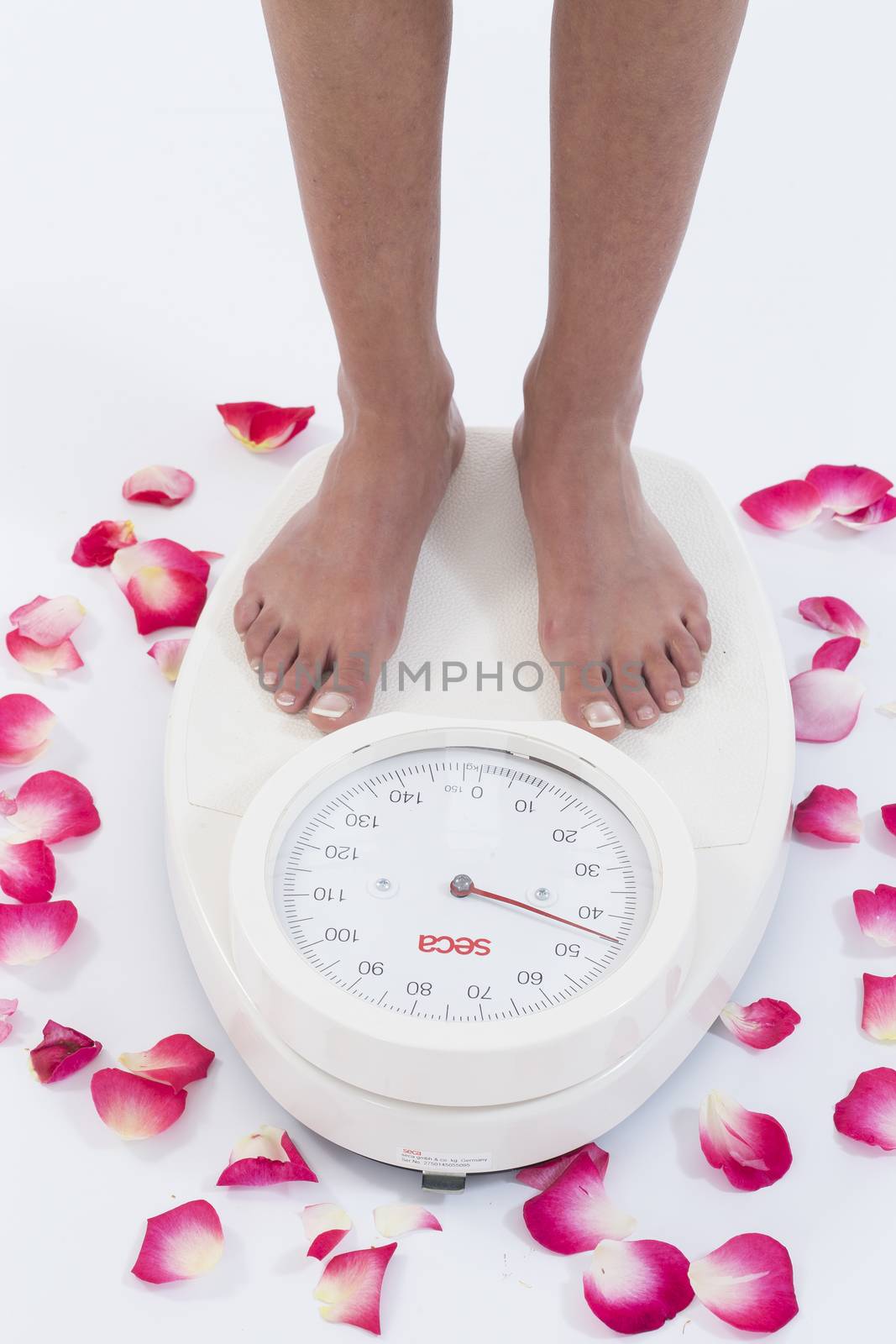 Woman stands on weighing scales isolated on white