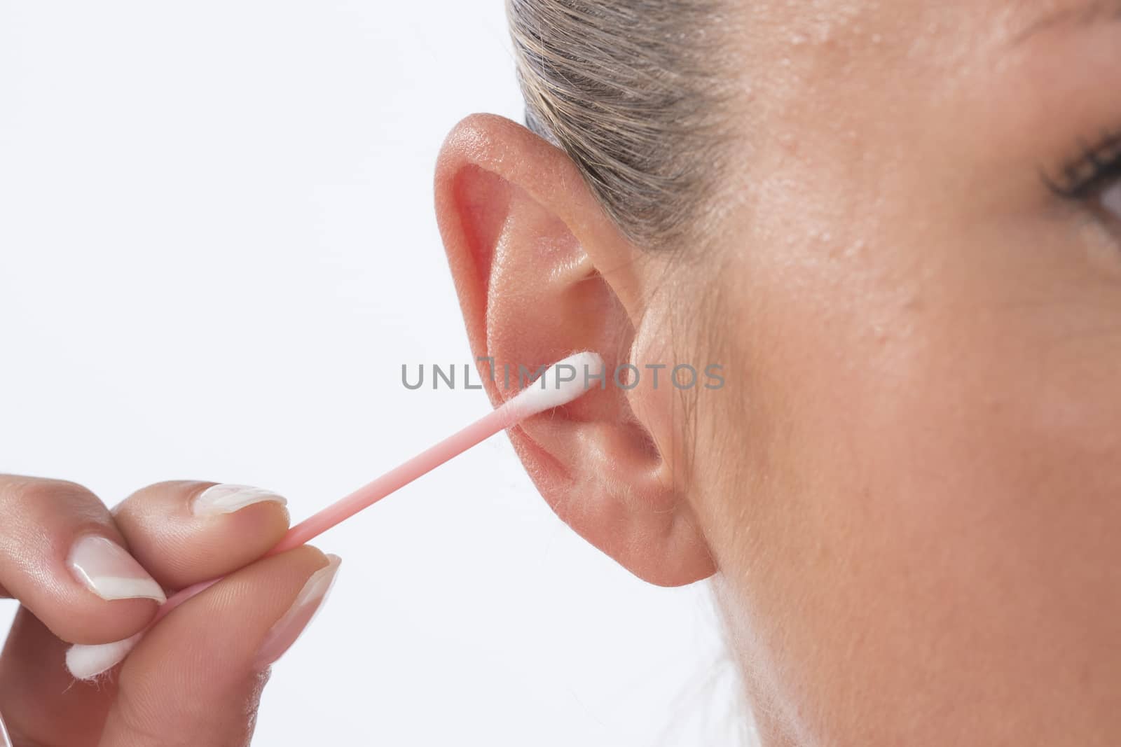 Woman cleaning ear using cotton stick by JPC-PROD