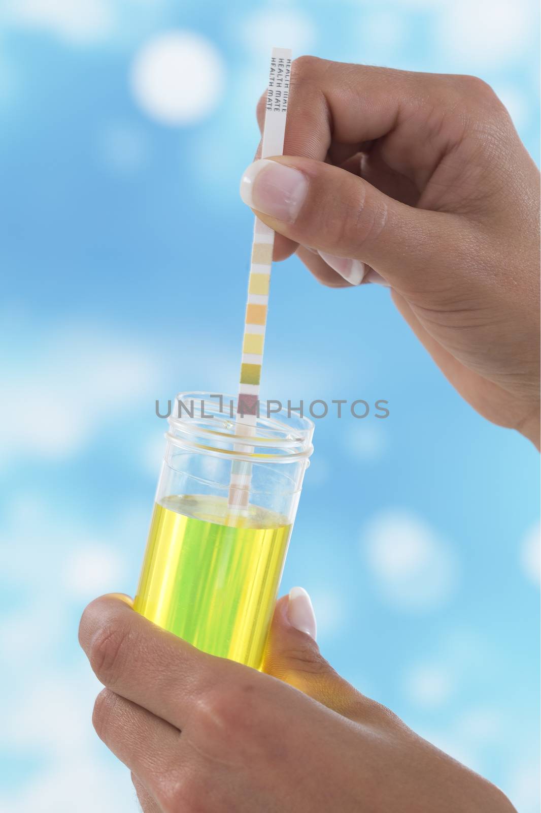 Urine test stripes examined by a young woman at home by JPC-PROD