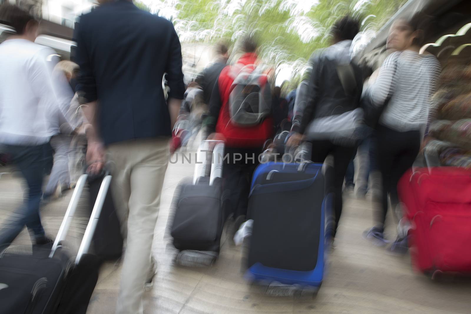 People with suitcases walking in the street in a big city. by JPC-PROD