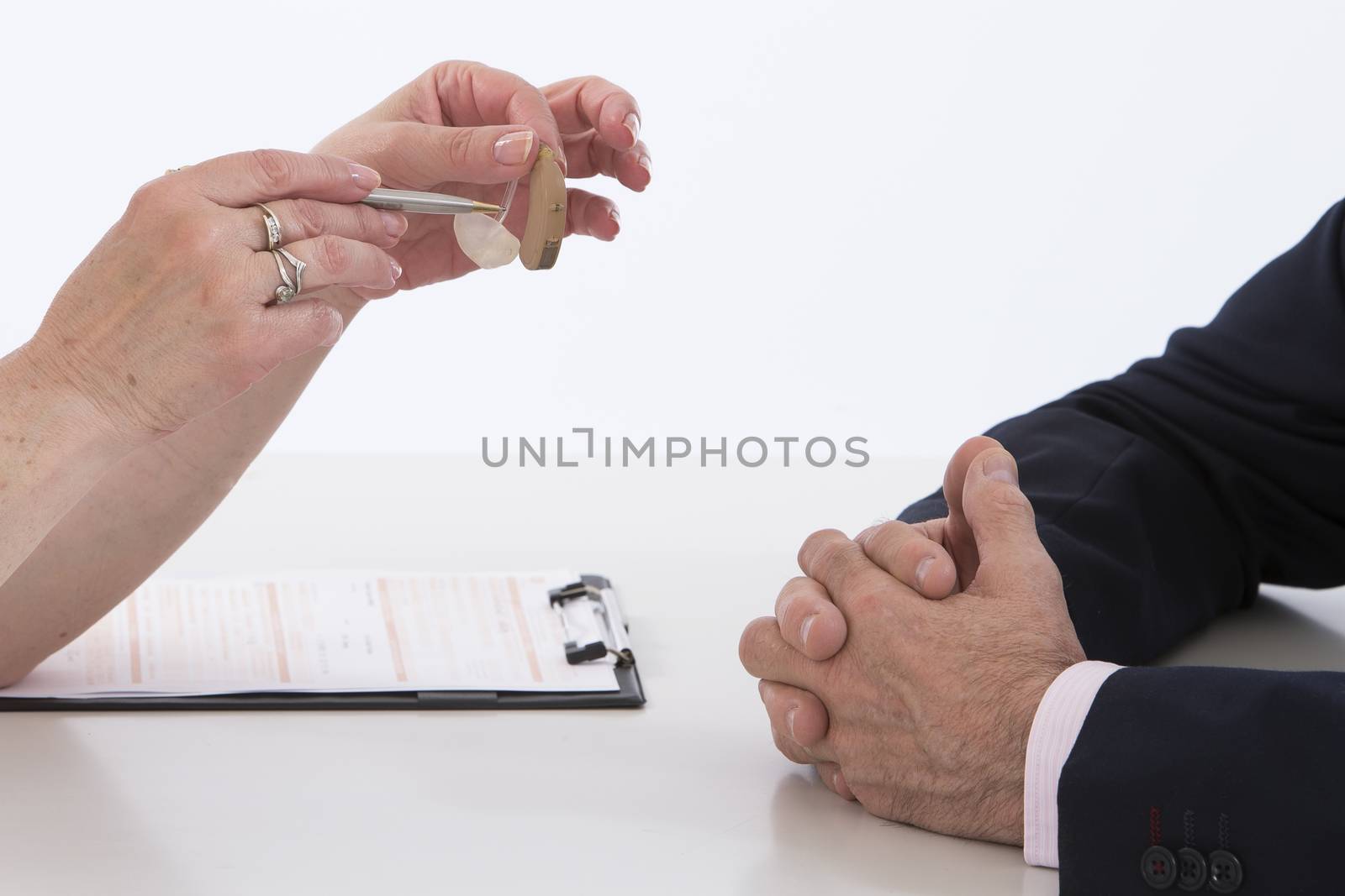 Doctor Showing Senior male Patient Model of hearing aid by JPC-PROD